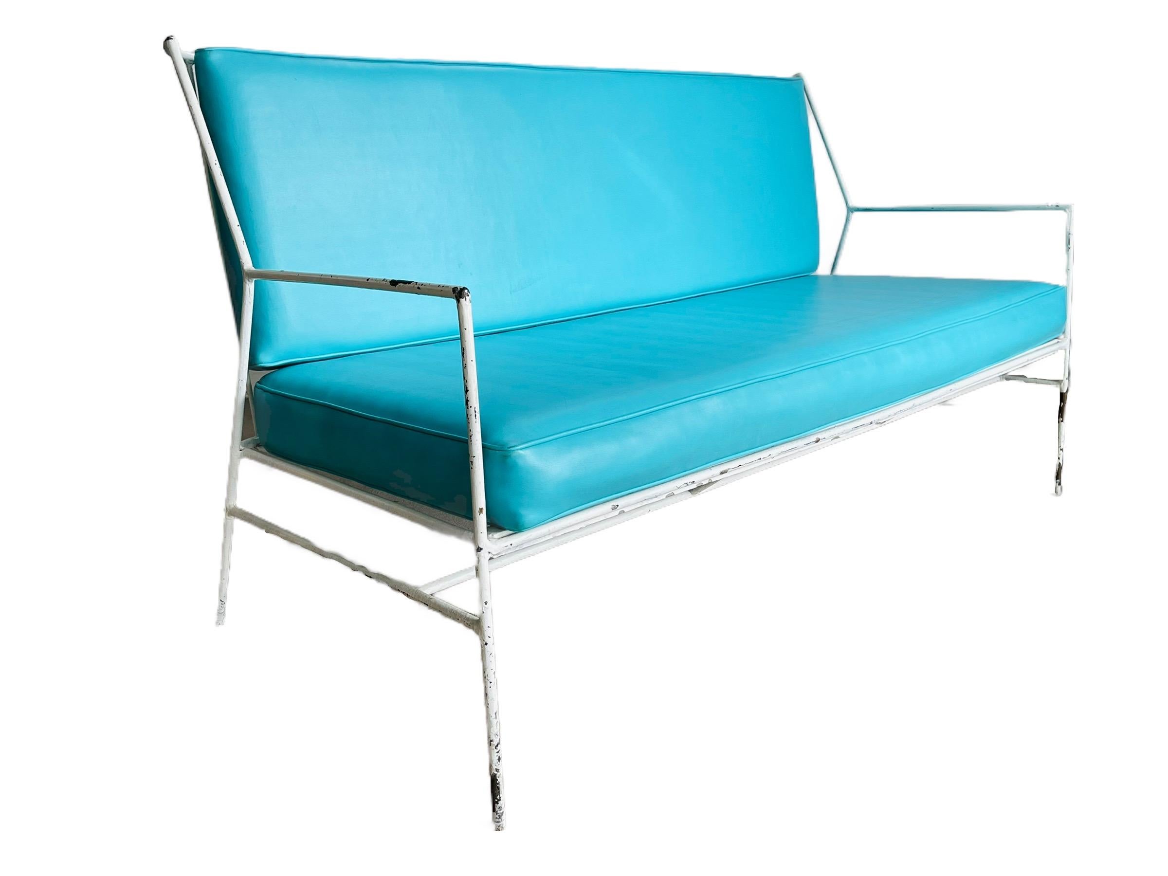 Iconic and rare metal sofa with original turquoise cushions designed by Paul McCobb as part of his Pavilion collection, circa 1950s. Some paint chip to the frame otherwise in good condition. Minor wear consistent with age and use. 

Measures: W