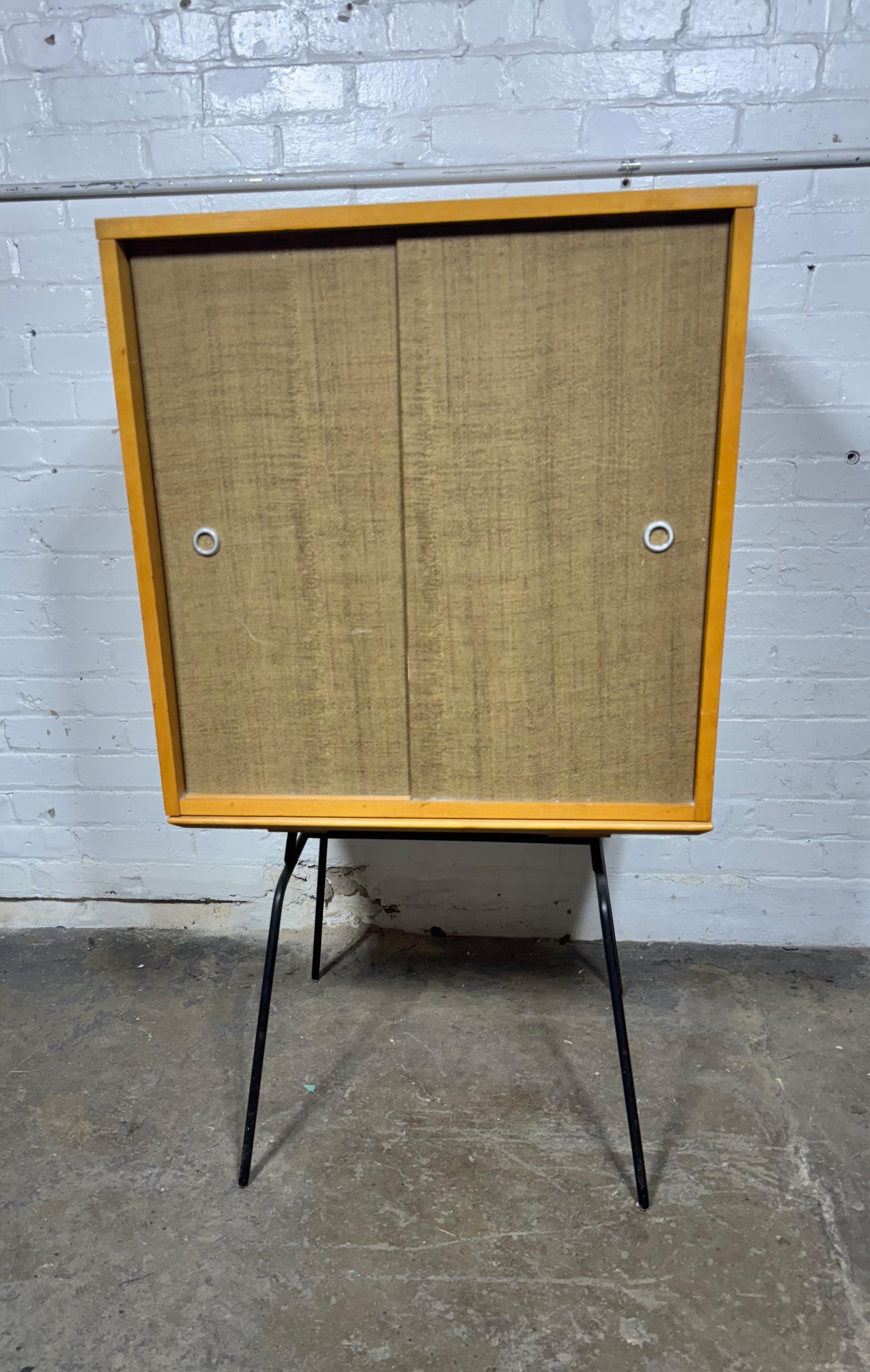 Unusual Paul McCobb Sliding door cabinet / bookcase on rare iron base, solid maple. retains original fabric covered sliding doors .. 40 years in the business , I have owned several Paul McCobb pieces ,I have never seen or owned this rare example on