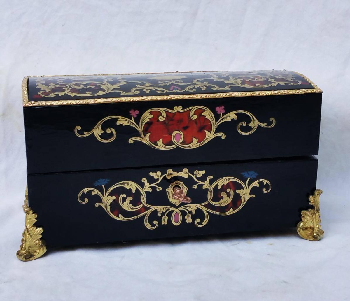 Rare perfume set in Boulle marquetry with five noble materials in Napoleon III style.
With its four original crystal perfume bottles.
Boulle style marquetry with inlays of brass, blue, rose and red bone and red horn.
Fine lingotière et resting on