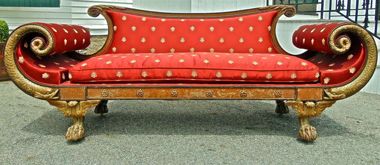 Rare Regency sofa similar to forms reputedly made for Brighton Royal Pavilion

--Well carved reverse curved dolphin arm rests
--Winged Egyptian claw feet carved to represent a crocodile foot
--Gilt brass rosettes
--Unusual depth for seating
--Fabric