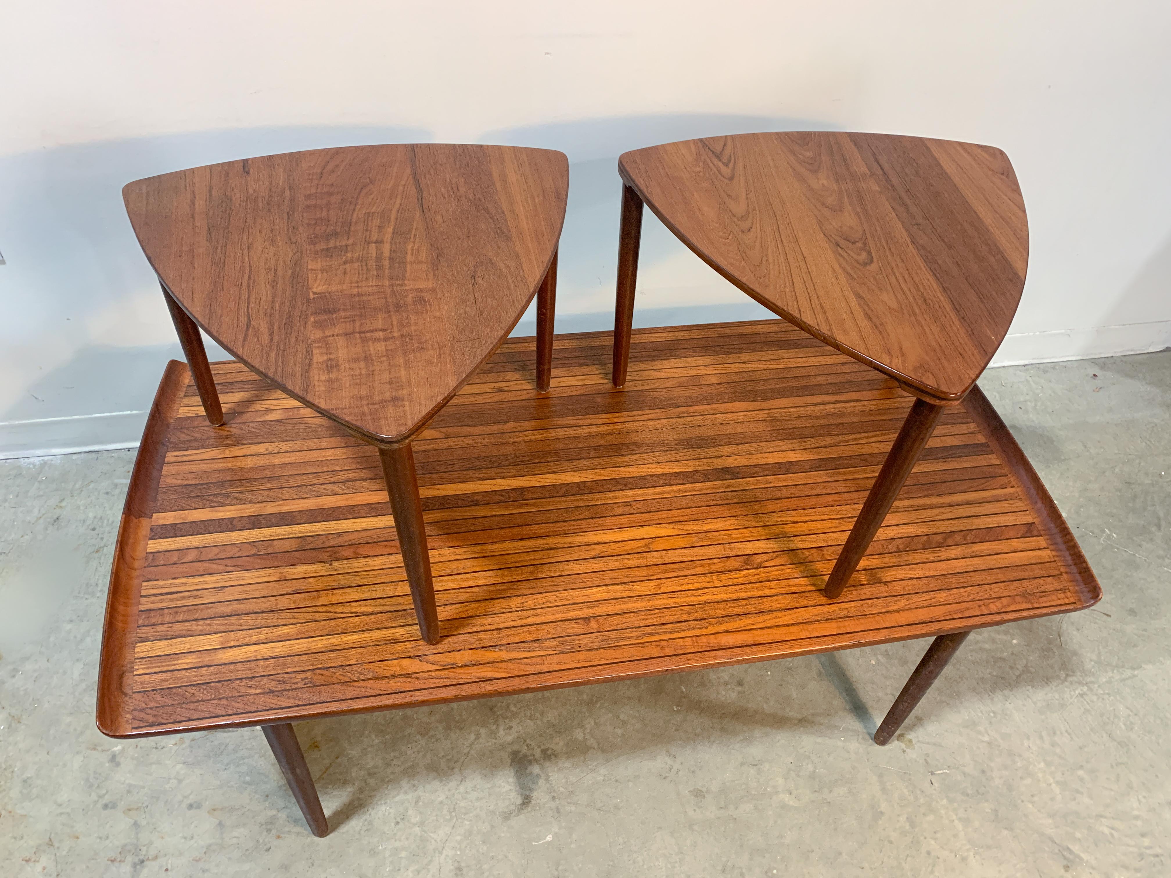 Very rare table set designed by Peter Hvidt and Orla Molgaard-Nielsen for France and Daverkosen in the mid-1950s. Set consists of a solid teak and wenge strip coffee table with a pair of solid teak triangular satellite tables that 'dock' underneath,