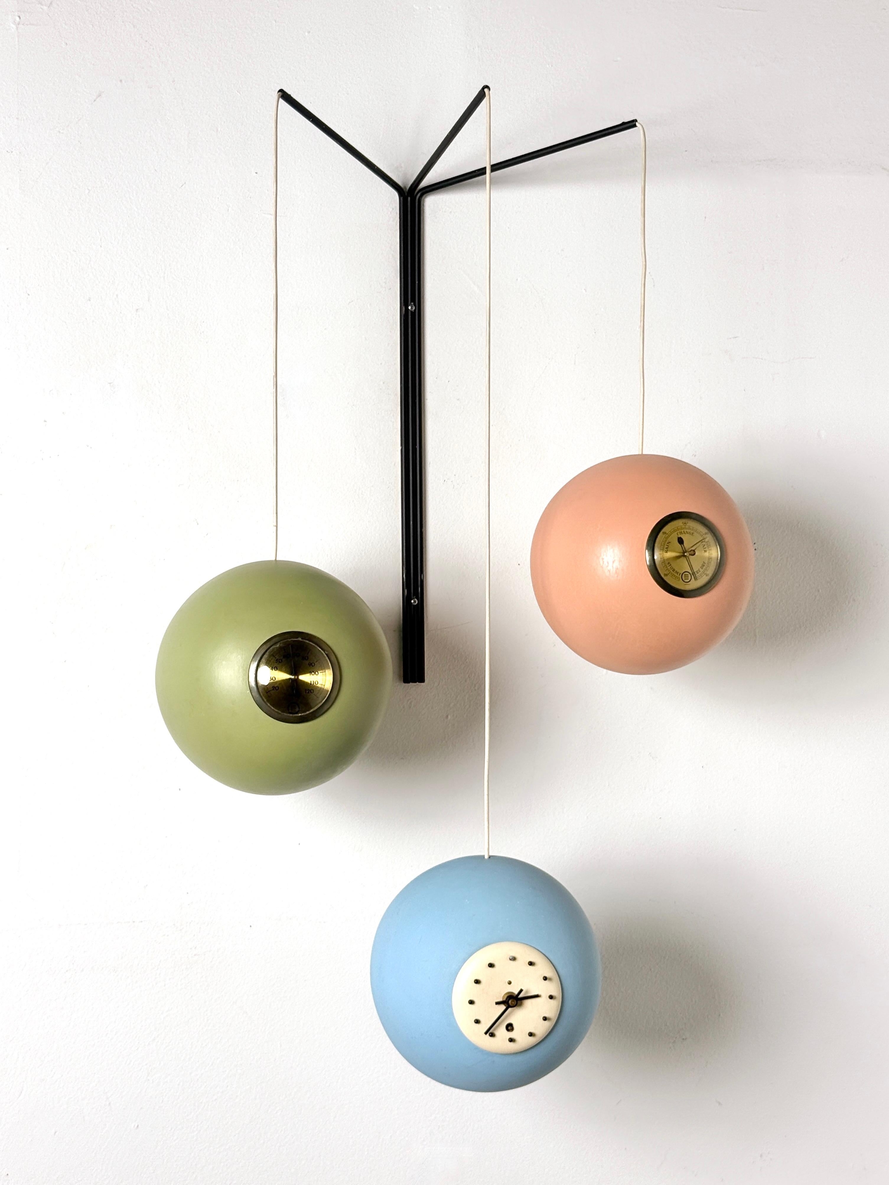 Eccezionale scultura di stazione meteorologica appesa di Peter Pepper Products 
Circa anni '50

Tre globi in ceramica con smalto opaco multicolore che contengono un termometro, un orologio e un barometro.
Sospeso da un supporto da parete in metallo