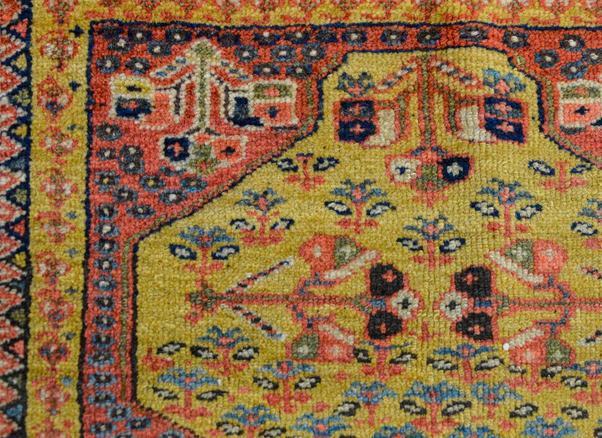 A rare petite late 19th century Persian Malayer rug with multiple petite geometric and petite floral patterned stripes woven in myriad colors including gold, green, pink, and light and dark indigo, and all surrounded a central medallion with petite