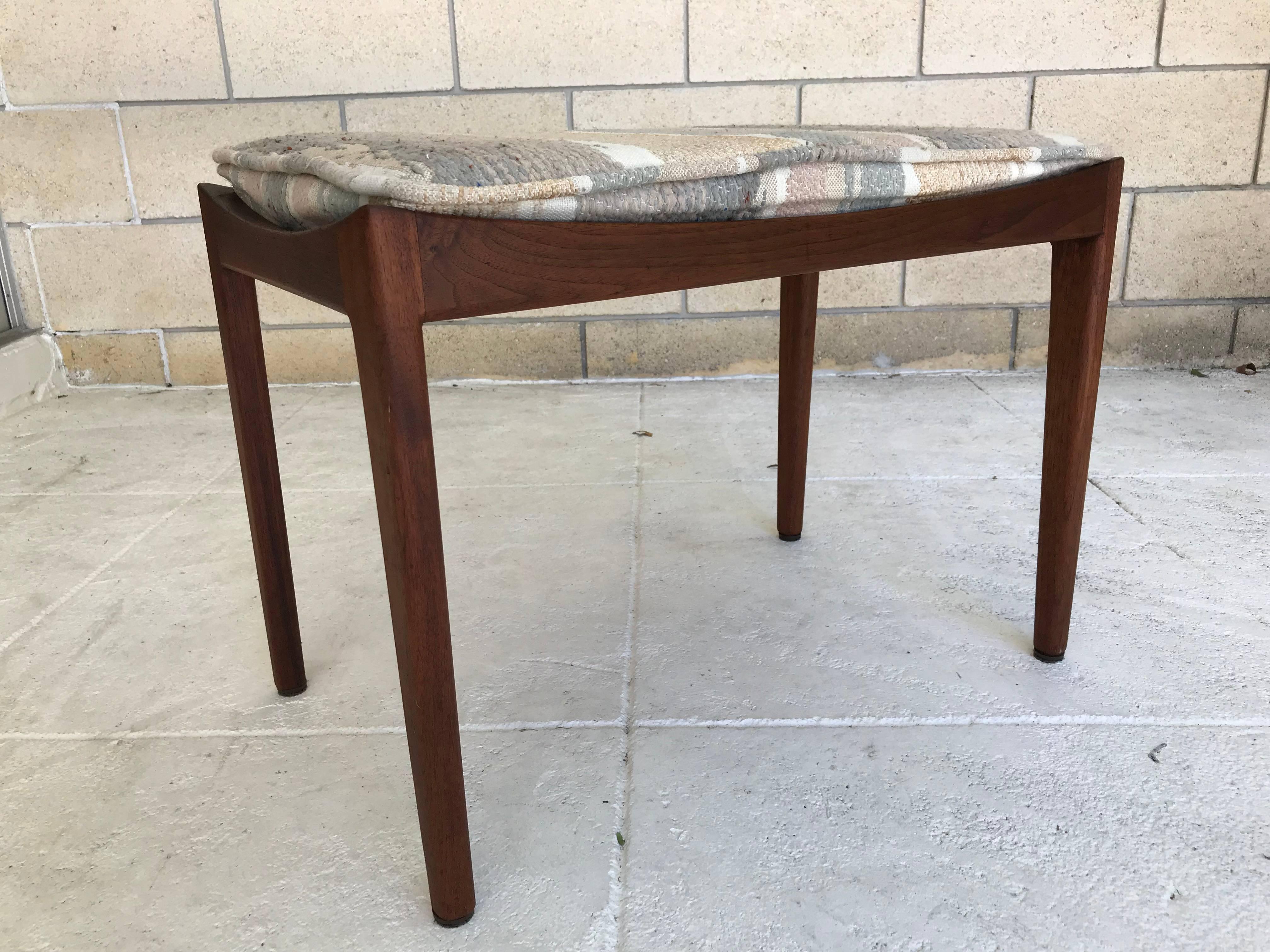 Rare petite occasional bench designed by Jens Risom. The bench came from the estate of an employee of Mr. Risom's and was re-upholstered in the 1980s I'm guessing. The foam needs to be replaced. The walnut cradle and legs are in original condition