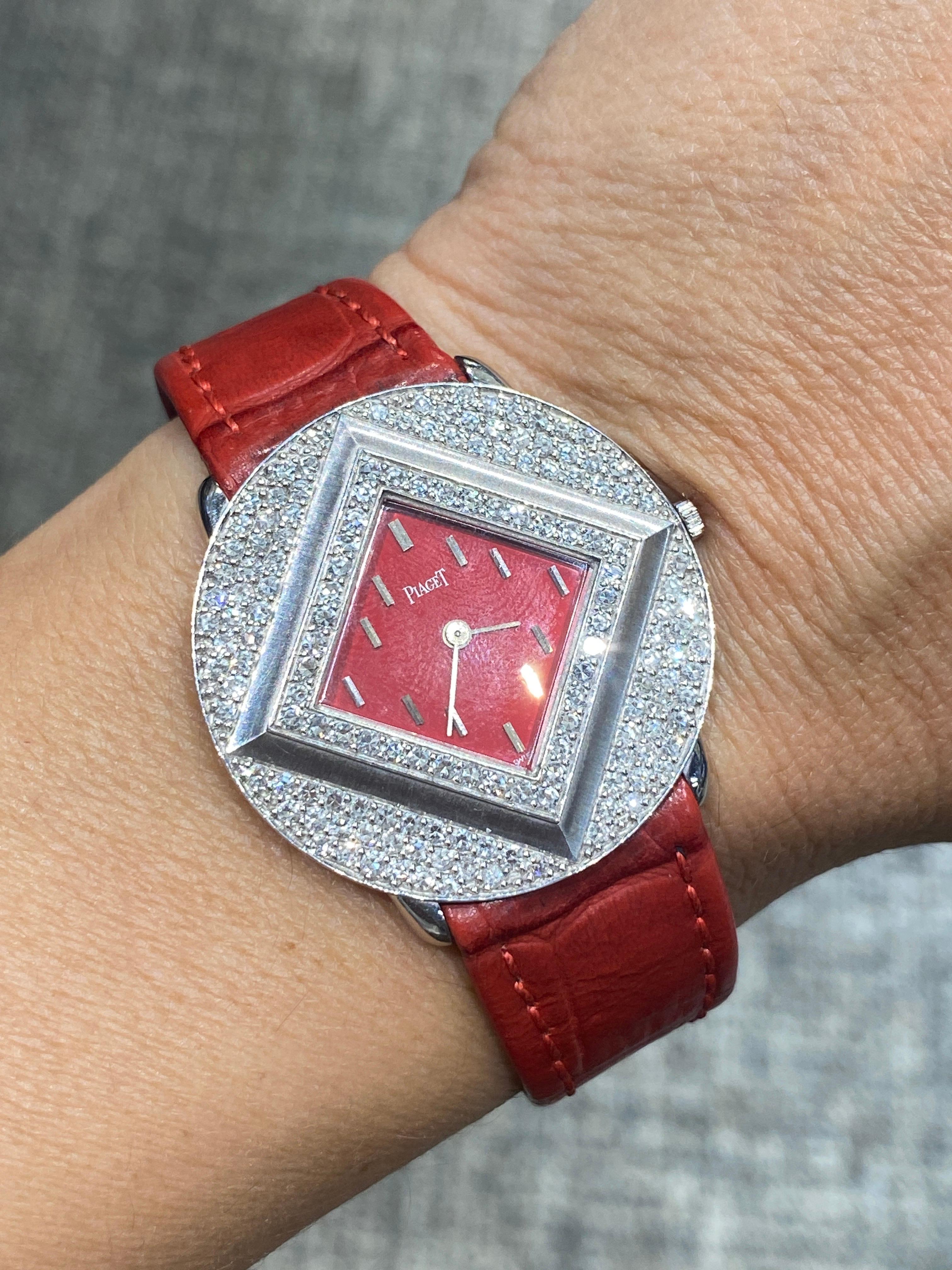 This very rare Piaget watch has a red enamel square dial within an 18 carat white gold circular frame adorned with diamonds. It is made in Switzerland, dates back to 1970s and is a wind-up watch. It is a striking piece and would make a great