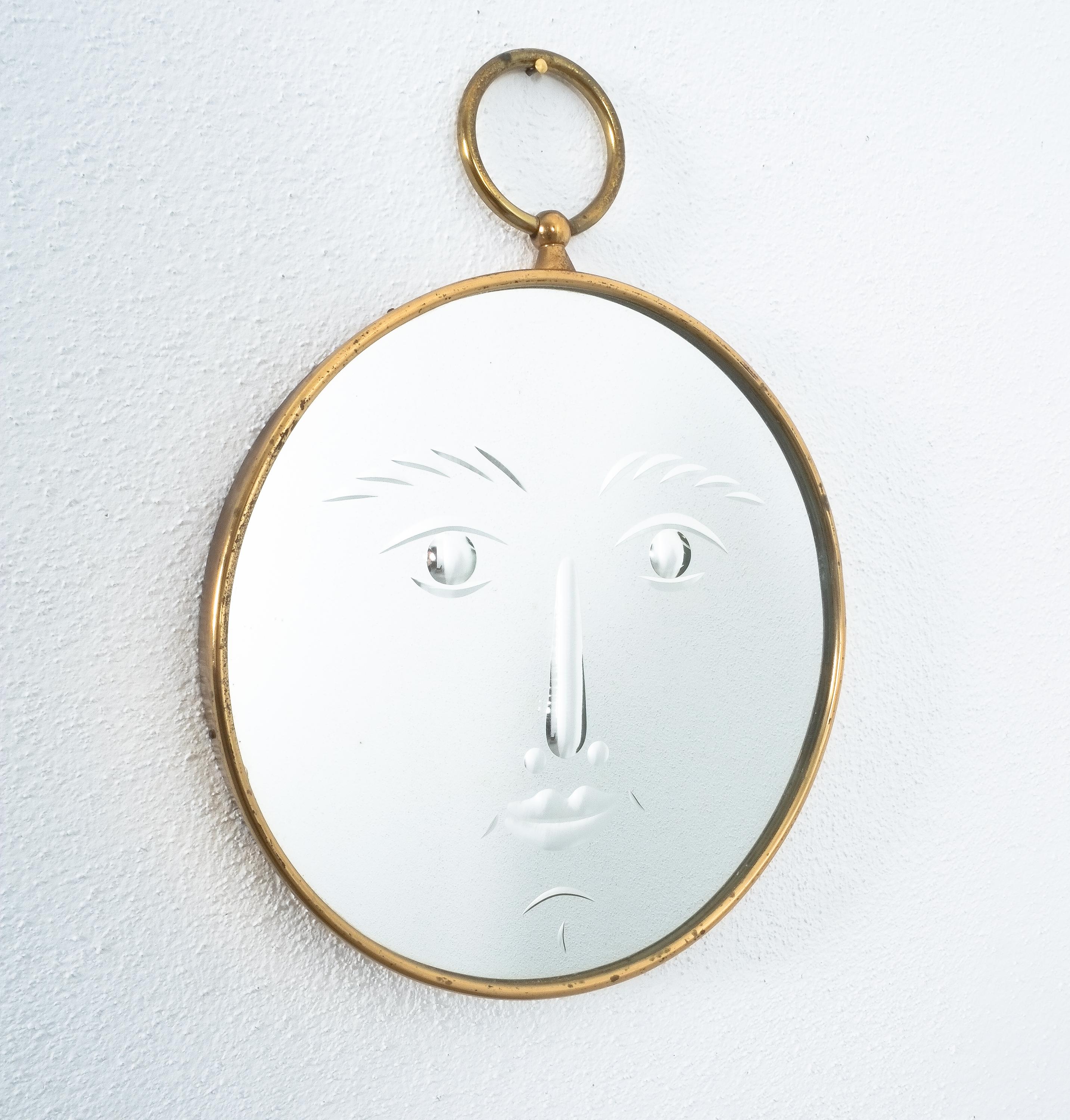 Very rare face mirror by Piero Fornasetti, Italy, from the early 1960.

Slightly smiling, charming mirror by Piero Fornasetti featuring a hand bevelled mirror glass in a brass frame. The mirror is in very good vintage condition. 

Literature: