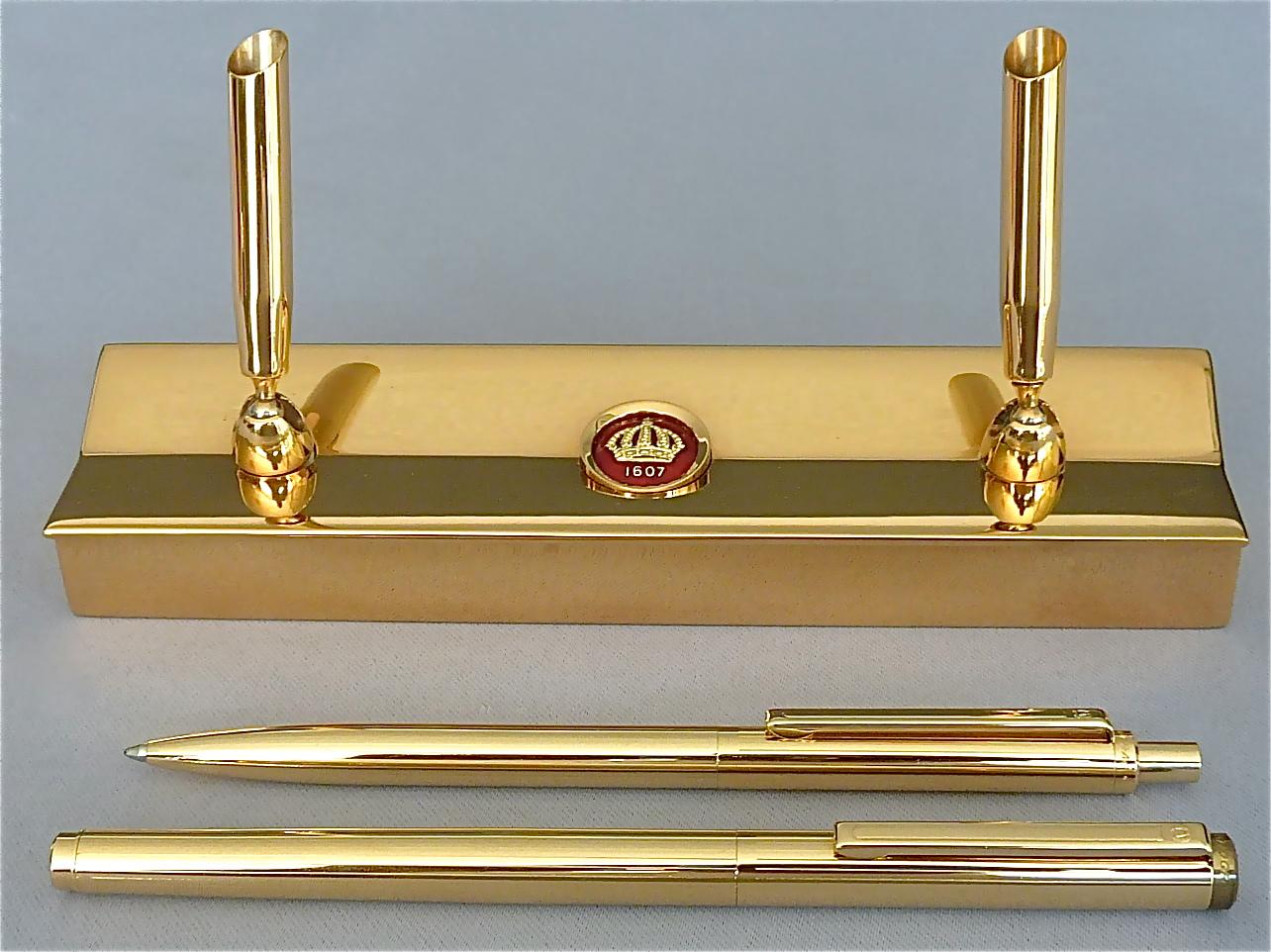 Rare and beautiful writing desk set designed by Pierre Forsell for Skultuna, Sweden circa 1960s-1970s. The heavy and high class quality set is made of gilt brass metal. It consists of a gilt ball pen and a fountain pen as well as a heavy base with