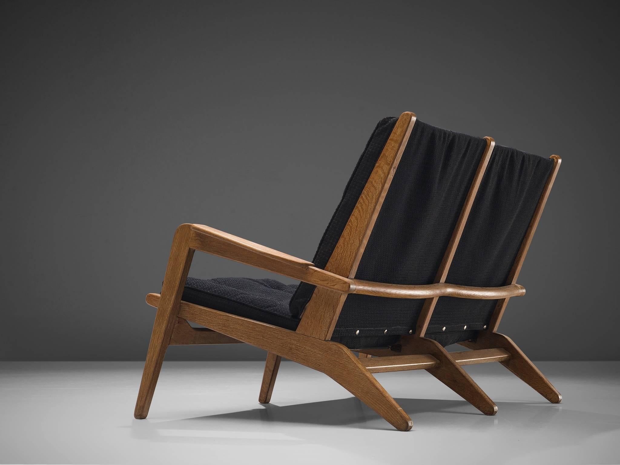 Pierre Guariche for Airborne, settee, solid oak, black fabric, France, 1940s.

This two-seat sofa in solid oak is designed by Pierre Guariche for Airborne. The structure with spring system supports the two thick padded black fabric cushions. The
