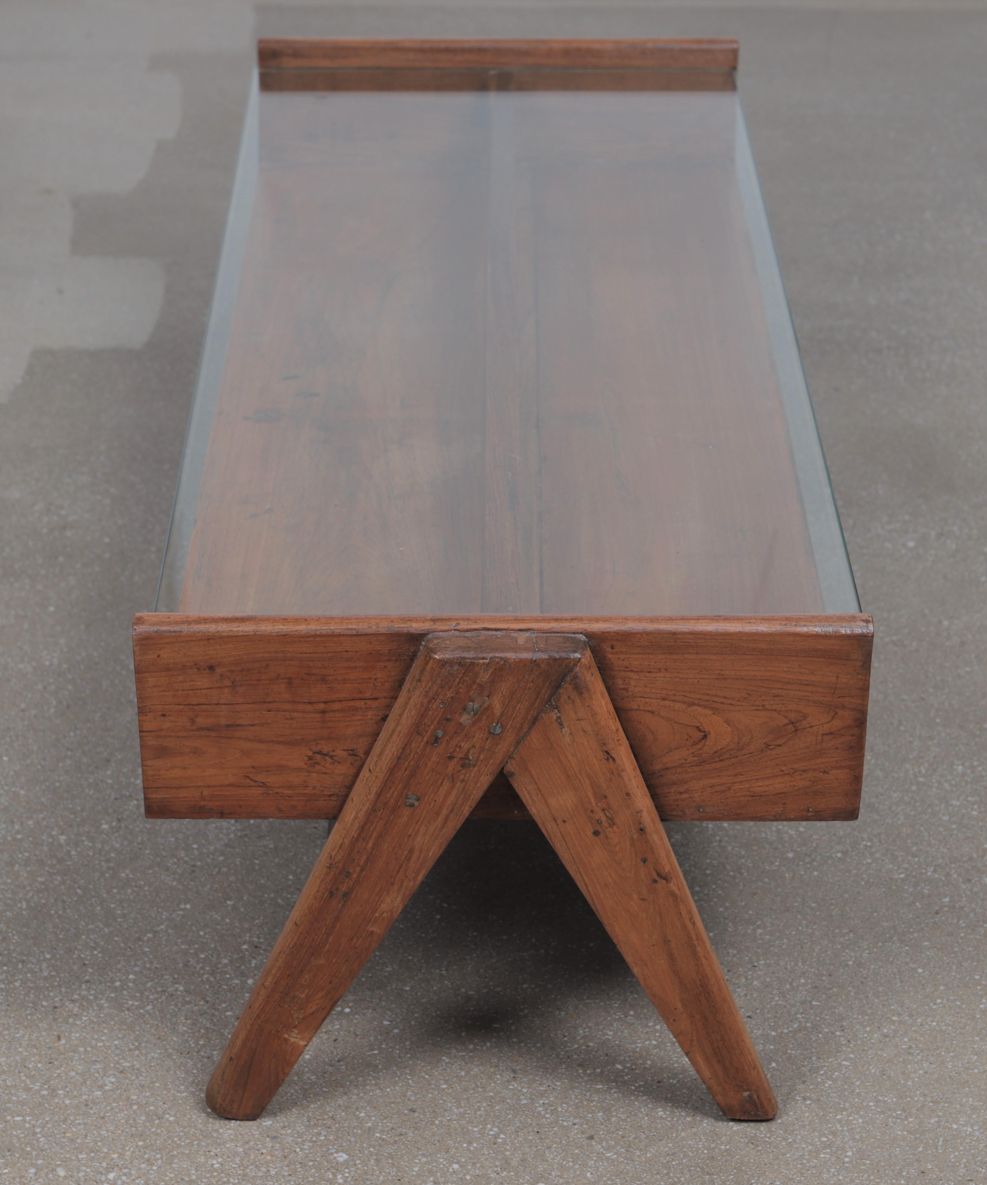 Coffee table with glass top, circa 1960.
Two feets type ‘V’ with open box, glass top.
Teak wood.
Provenance: Assemblée, bâtiments administratifs, Private House Chandigarh, Inde.
Measures: H 38.5, L 119, P 46 cm.
A certificate of expertise will