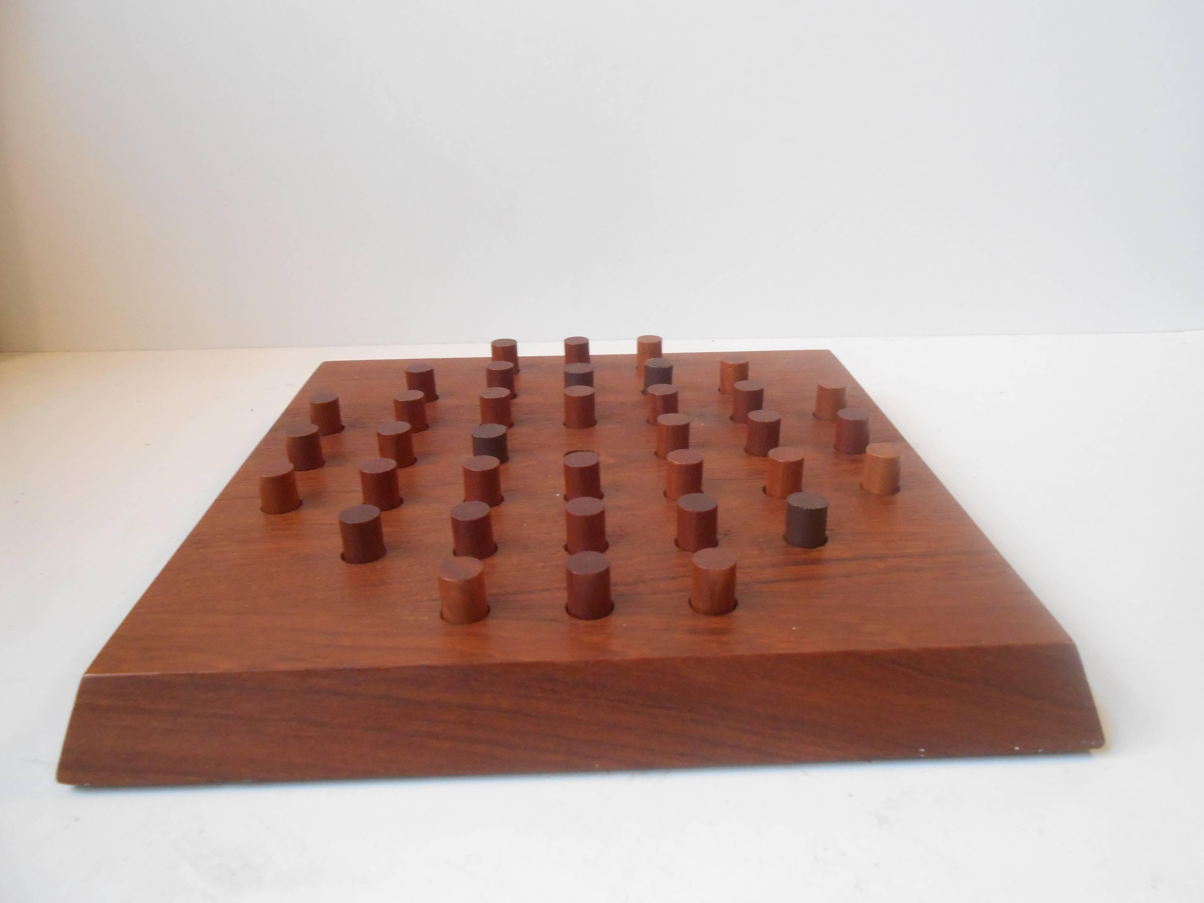A solid teak Solitaire game designed by Piet Hein (1905-1996) in the 1950s. Manufactured by Skjode in Skjern, Denmark, during the 1960s. Stamped underneath: Piet Hein, Skjøde, Denmark. Measurements: 25 x 25 cm (10 x 10 inches). Very nice condition