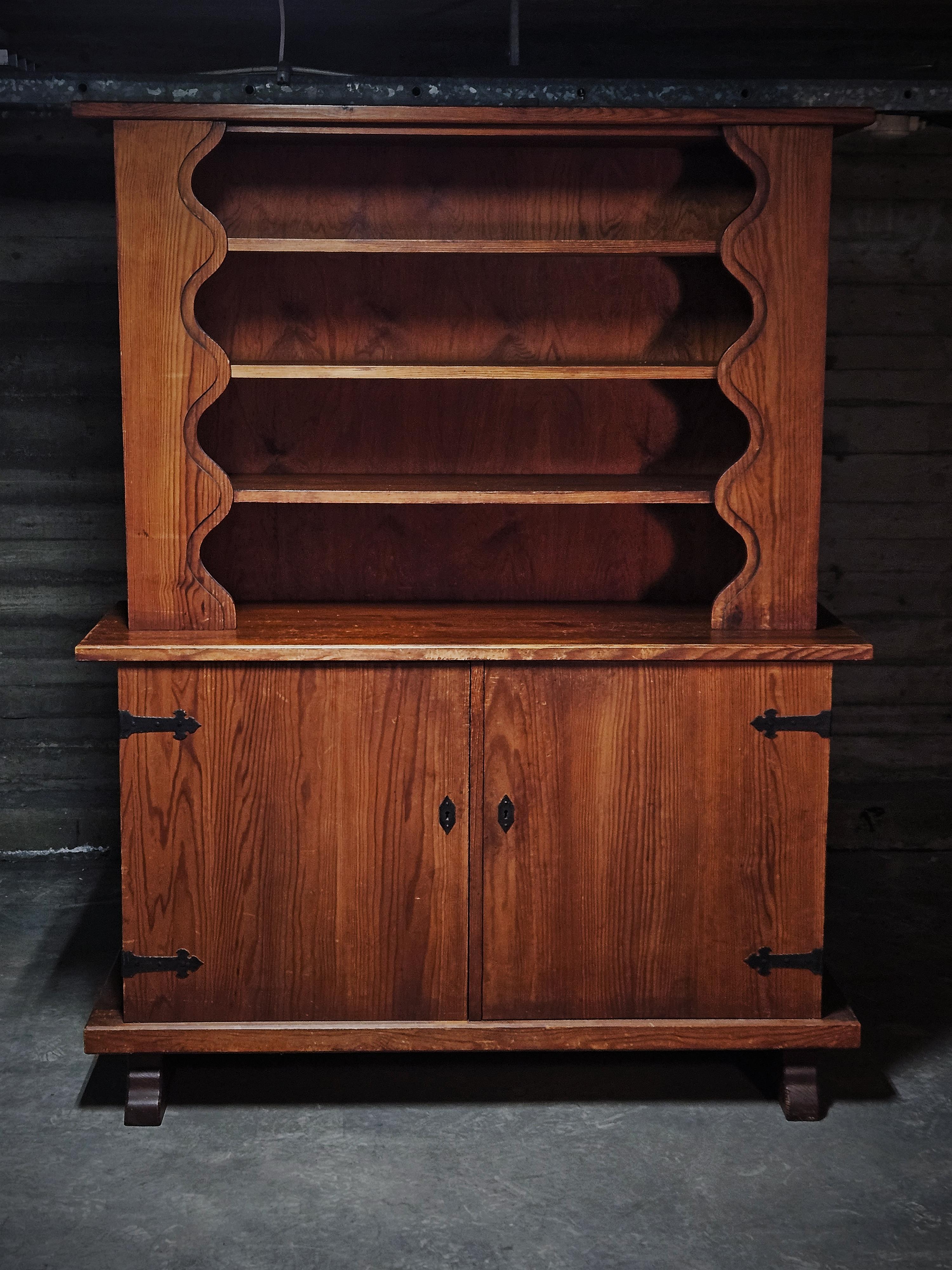 Very rare cabinet produced by Åby Möbelfabrik, Sweden, 1940s. 

Made in solid pine with elements of iron. 

The wavy form of the top shelf as well as the legs of the cabinet makes you think of Axel Einar Hjorts sports cabin furniture produced by