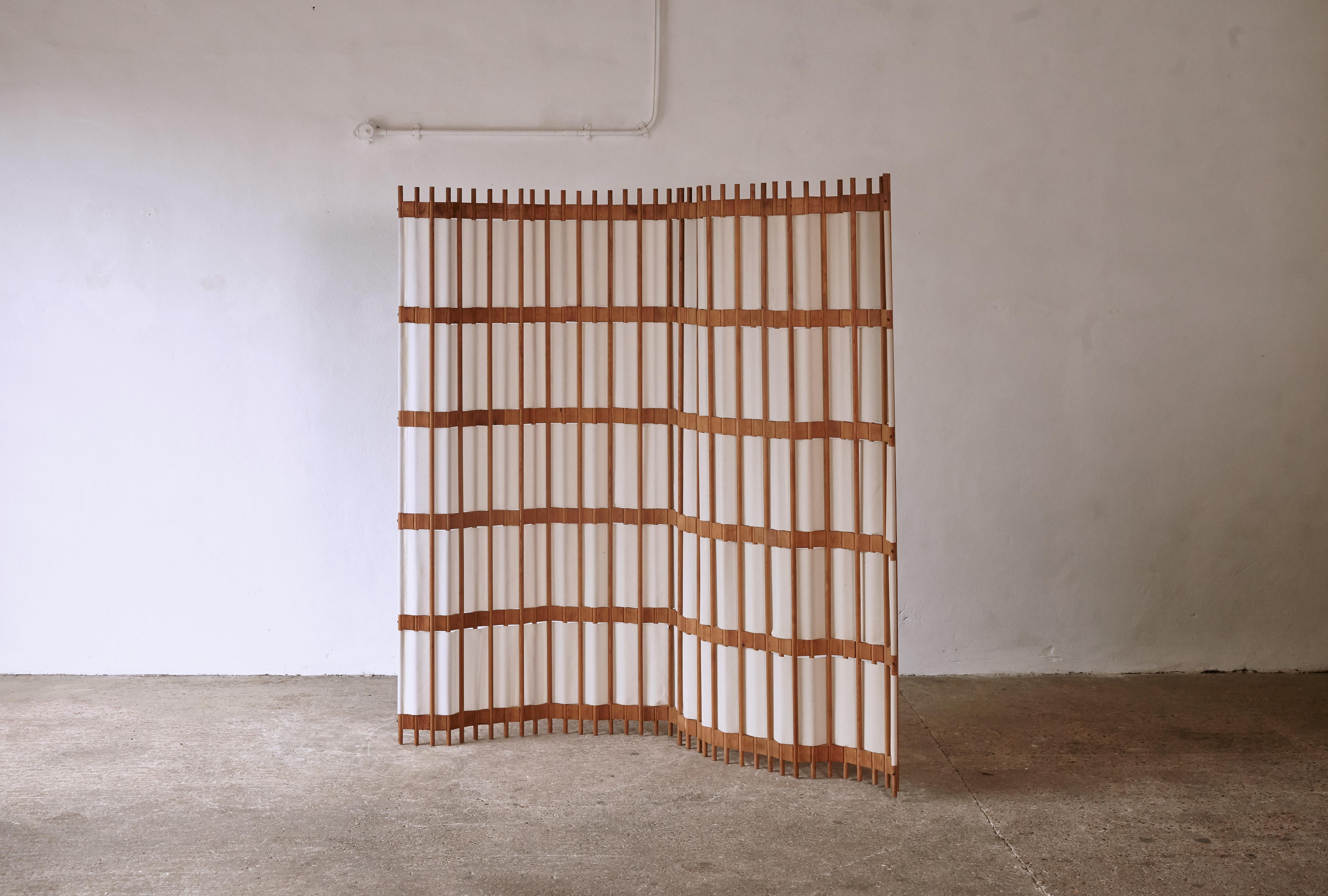 A rare pine screen / room divider, Sweden, 1960s/70s. In good condition with minor signs of age and wear relative to age and use. The screen curves and bends and can be put in various positions. The material is a lampshade type material with a
