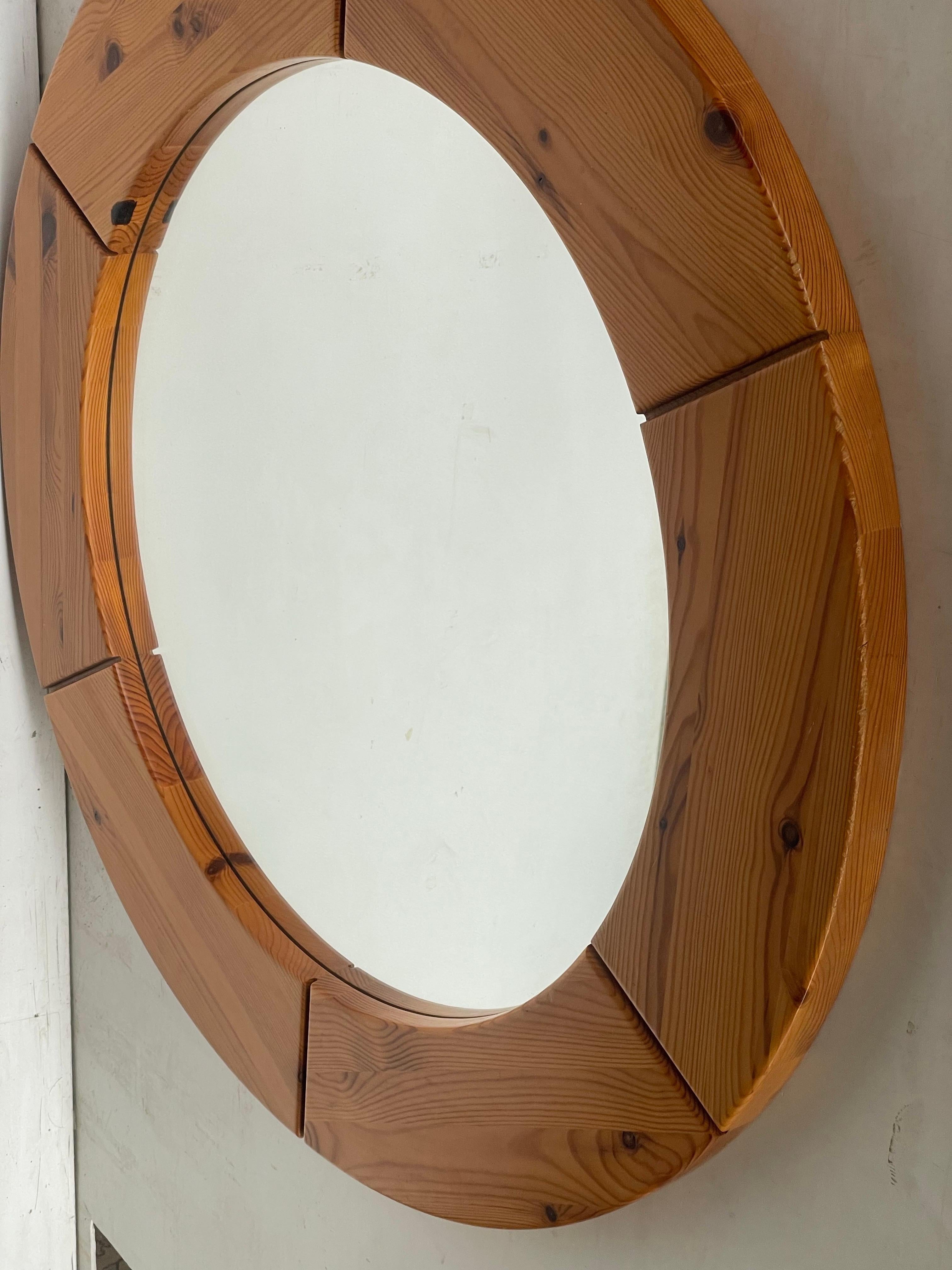 
Ce grand miroir mural rond, fabriqué par Glasmäster Markaryd en Suède dans les années 1960, présente un cadre en pin massif avec une finition naturelle et chaleureuse. Les veines et les nœuds du bois ajoutent du caractère, tandis que le design