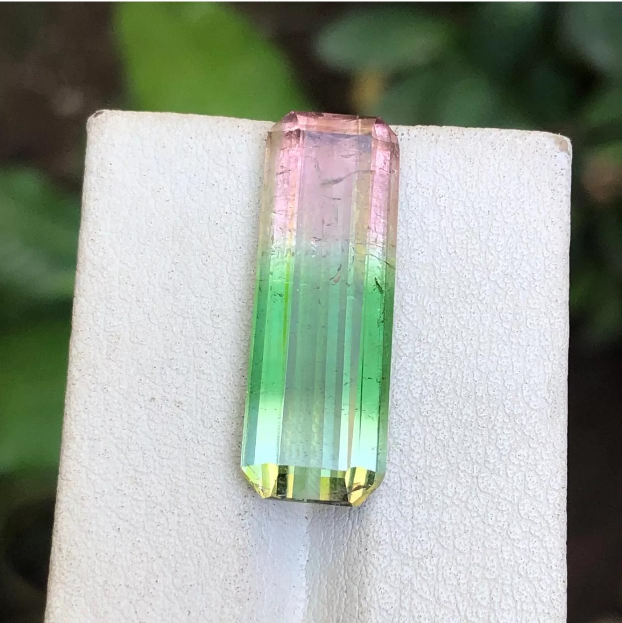 GEMSTONE TYPE: Tourmaline 
PIECE(S): 1
WEIGHT: 13.45 Carats
SHAPE: Emerald
SIZE (MM): 25.48 x 8.92 x 6.27
COLOR: Captivating tricolor gradient, seamlessly transitioning from delicate pink to vibrant green, and ending in a subtle aqua hue
CLARITY: