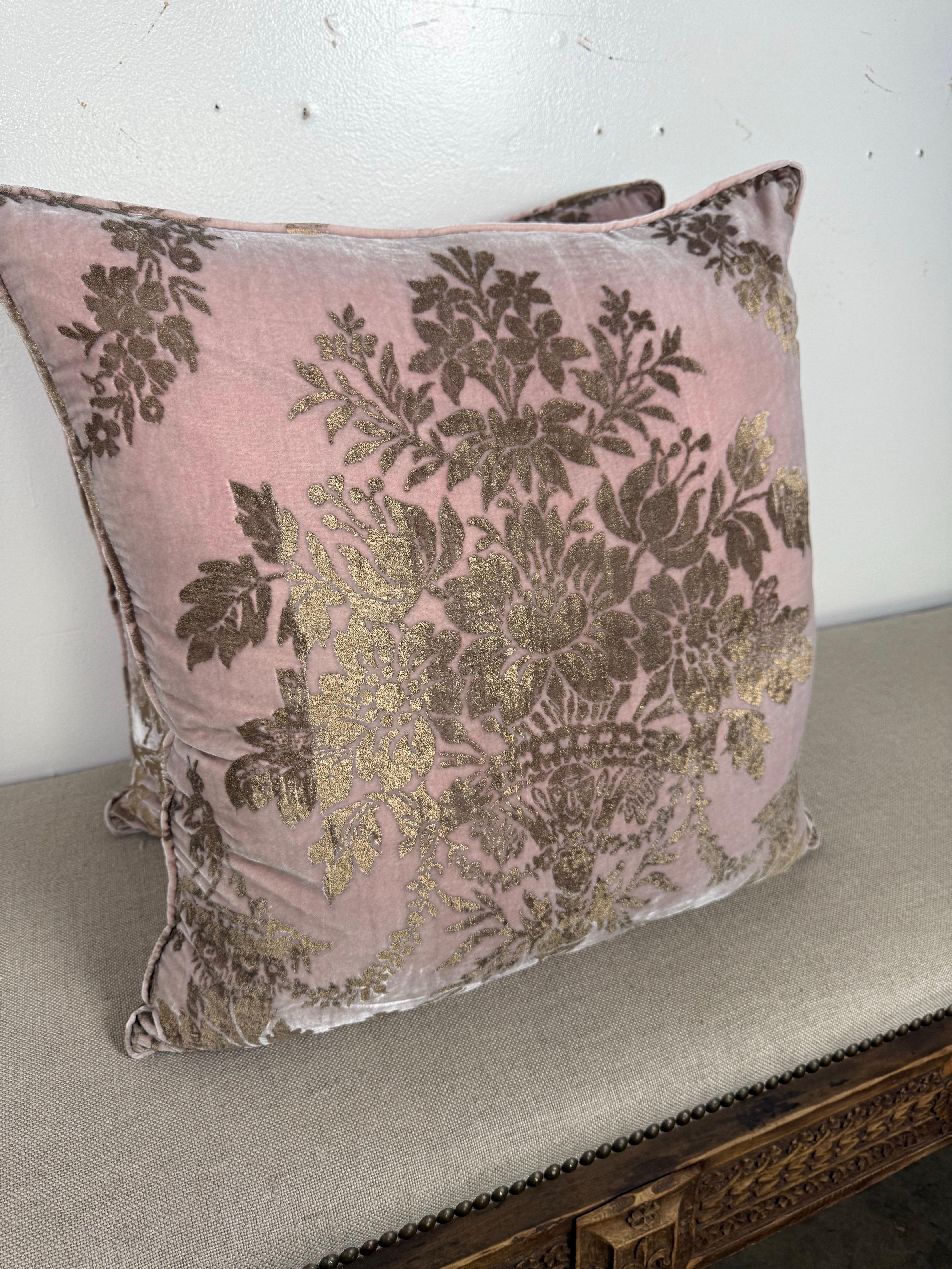 Este impresionante par de cojines Fortuny vintage presenta un diseño de terciopelo rosa y dorado especialmente raro y único, lo que los convierte en auténticas piezas llamativas para cualquier interior elegante. La parte frontal muestra un motivo
