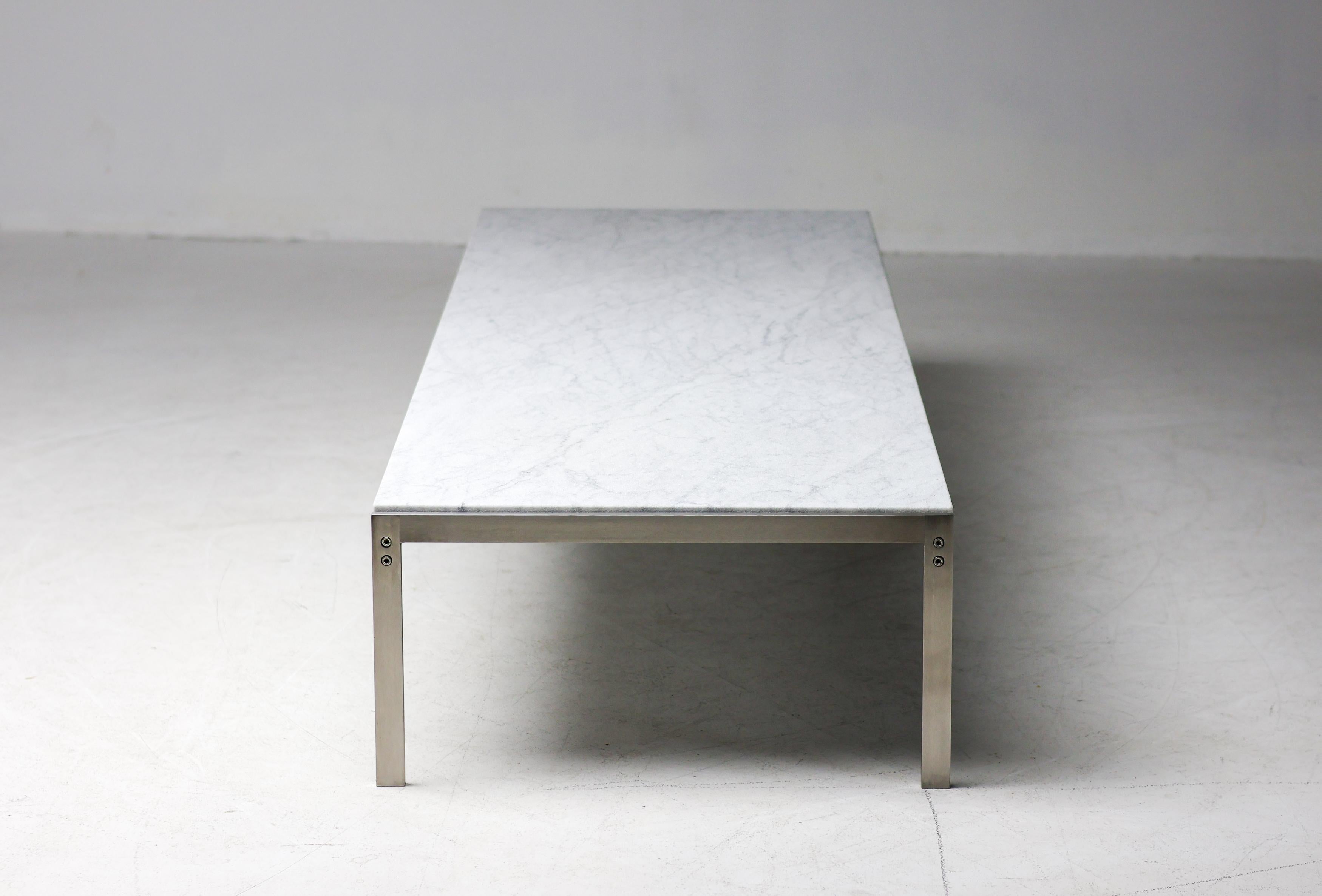Diseñada en 1968 por el famoso arquitecto y diseñador danés Poul Kjærholm, la mesa de centro PK63 es una clase magistral de minimalismo refinado. Su preciso armazón de acero inoxidable soporta una llamativa encimera rectangular de mármol laminado de