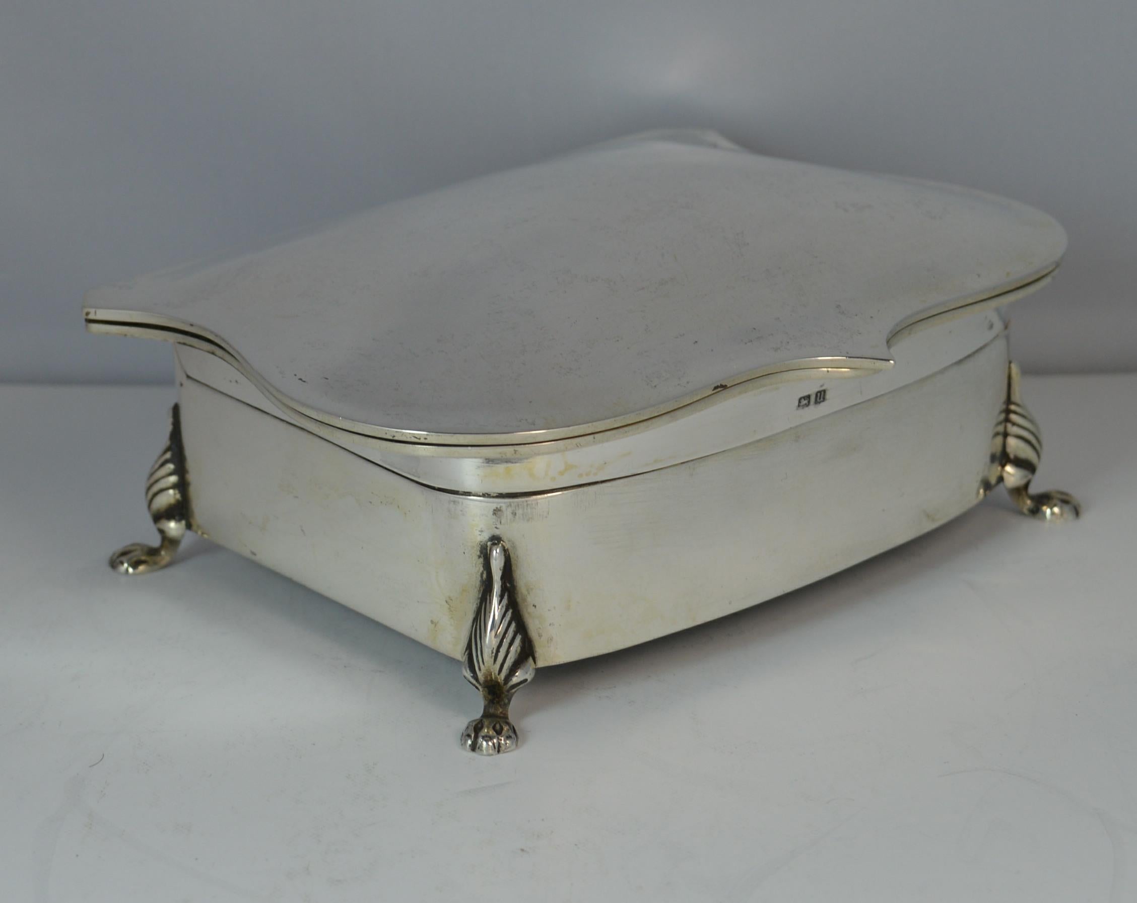A beautiful English made solid silver jewellery box.
Stylish shaped piece with plain finish throughout and standing on four lion feet.
Unusual design with top tier for thirteen rings and the tier below plain for chains, pendants etc.

Hallmarks ;
