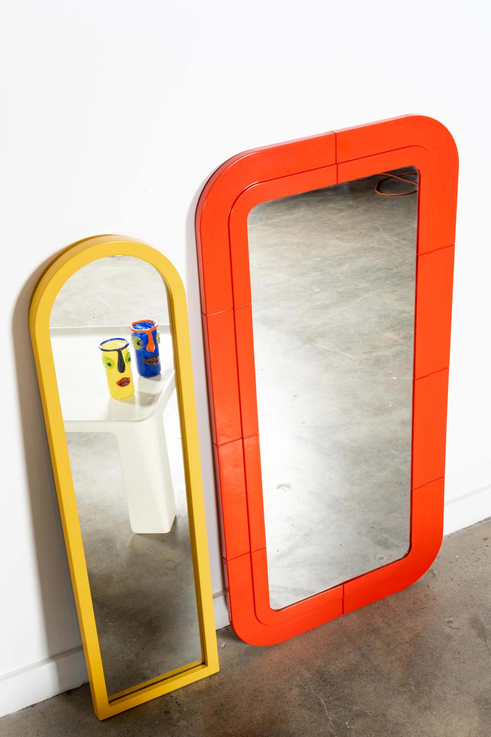 Moulded plastic frame mirror in bright cherry red, by designer Anna Castelli Ferrieri for Kartell. Attribution stamp on back of piece shows 'Made in Italy'.
