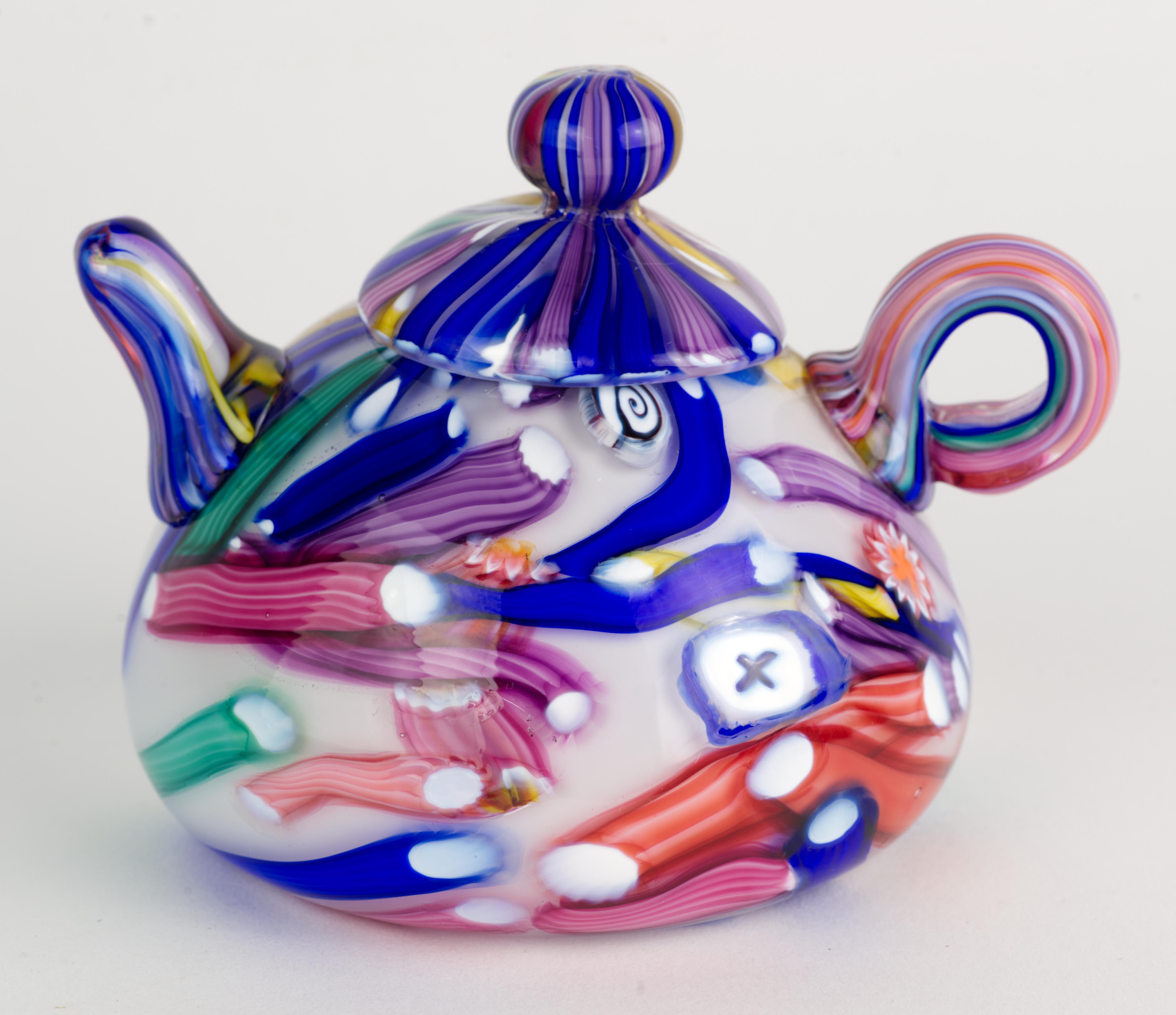  Rare et ludique, ce presse-papier a été soufflé à la main en forme de théière avec de joyeux millefiori multicolores et des inclusions de murine à l'intérieur d'une couche de verre transparent entourant un fond de verre blanc solide.  L'utilisation