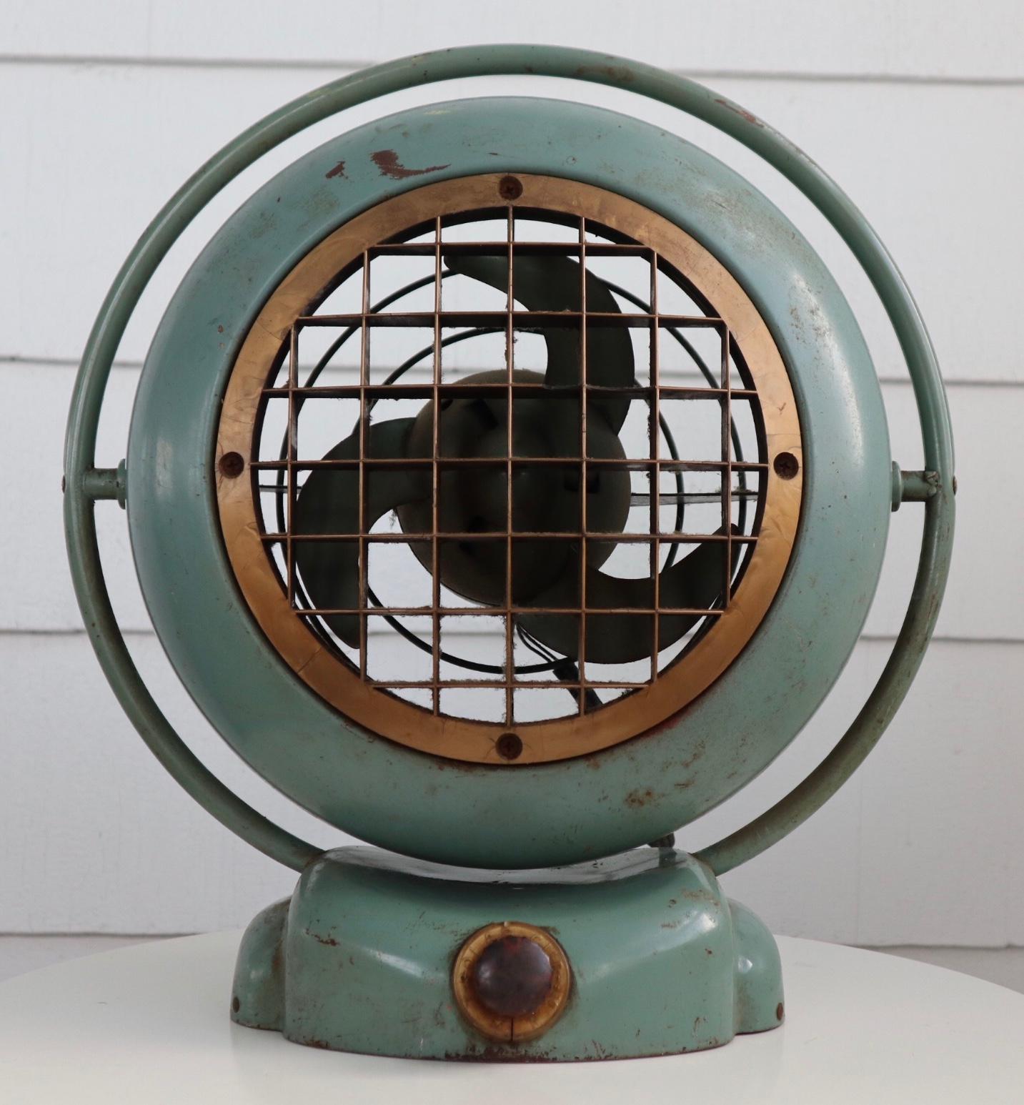 This piece boasts a gorgeous seafoam green color with a patina to die for. It works and blows air at 3 speeds. Metal construction with elegant design evocative of Midcentury aviation styling and also looks like an antique diving helmet. Original