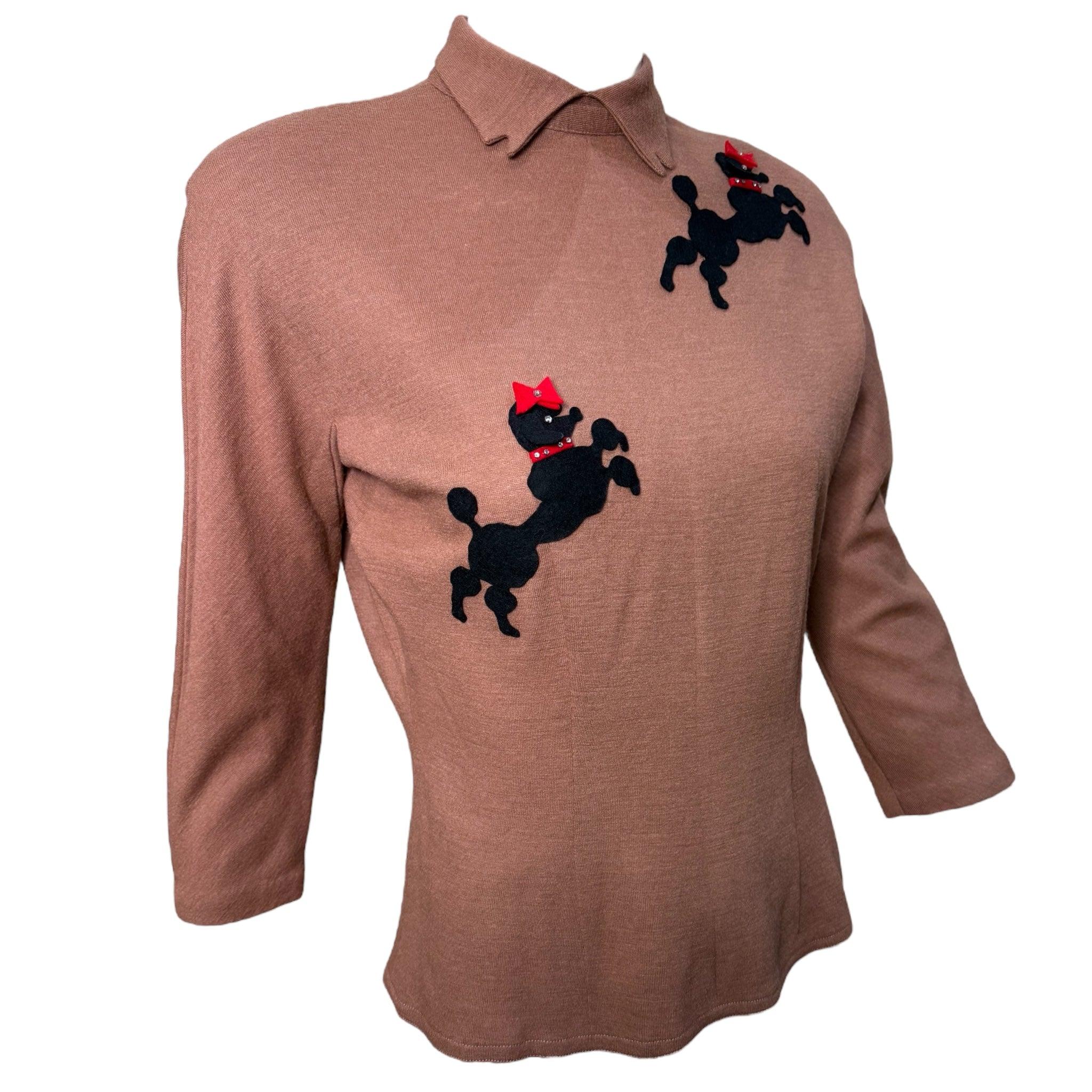 Wuff! Entzückender und sehr sammelwürdiger Pudelpullover aus den 1950er Jahren. Ein amerikanischer Klassiker! Mokkabraun aus leichtem Wolljersey. Gekerbter Eselsohren-Kragen. Schwarze Pudel aus Filz mit roter Filzschleife und Kragenverzierung.