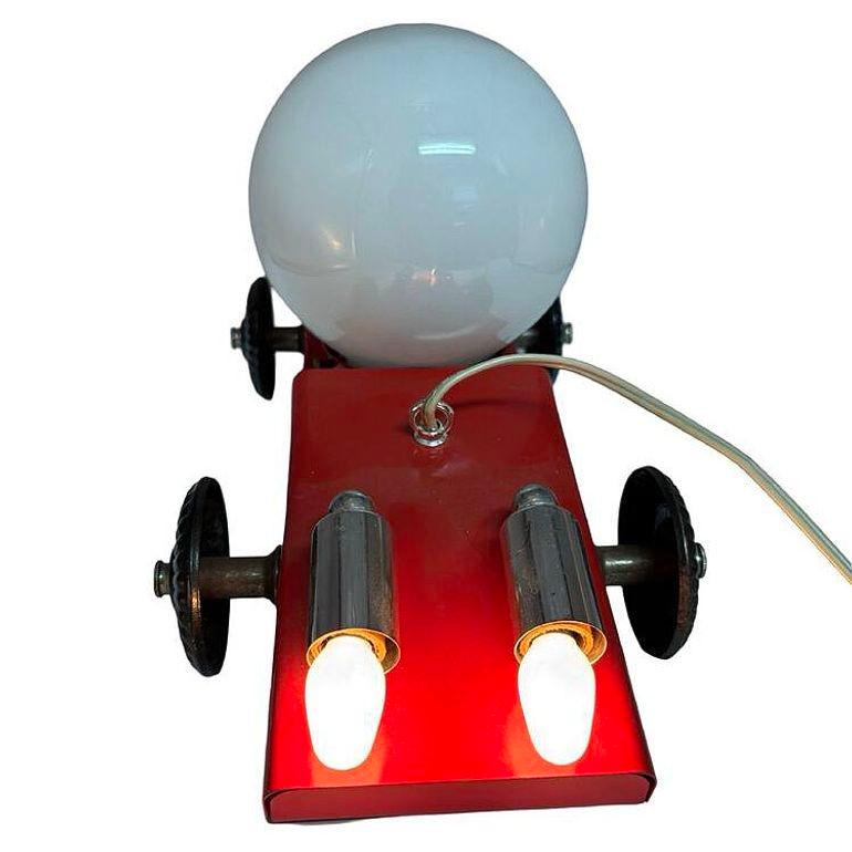 Late 1970s Pop Art red race car chandelier/pendant Lamp featuring a very Memphis-inspired design with simple playful almost cartoonish colors and forms with a post-modern geometric design. The body is made from formed sheet metal that has been