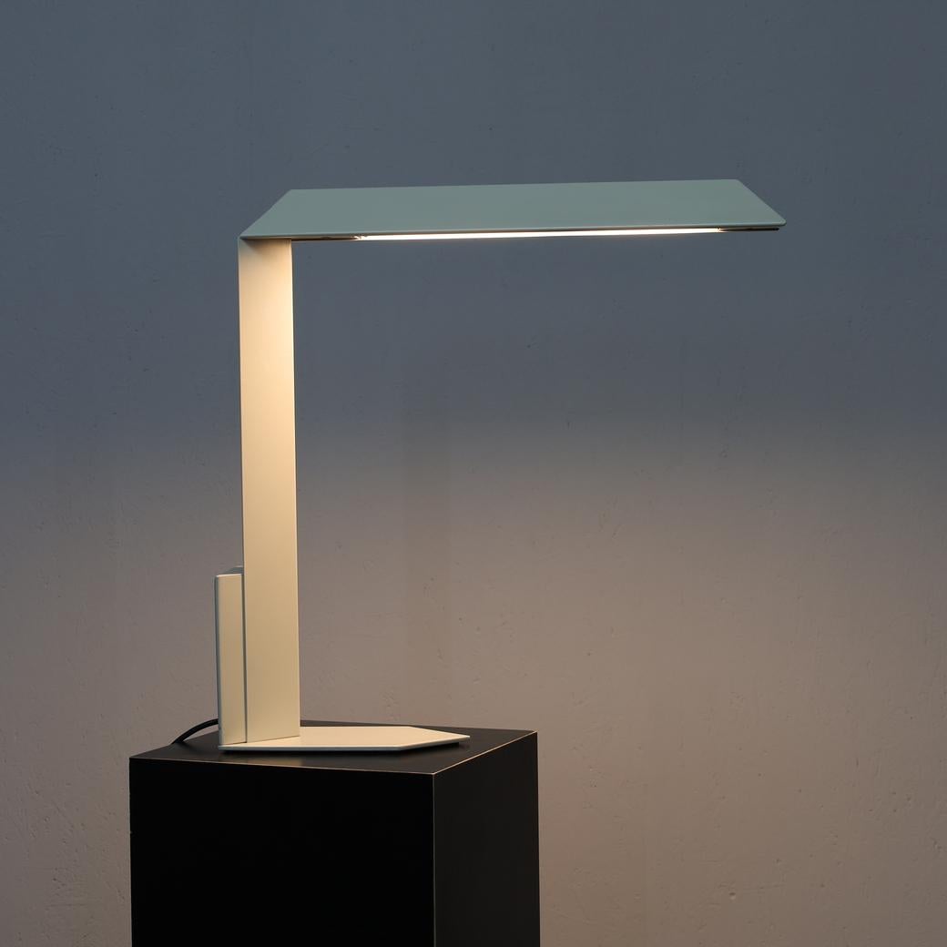This striking desk lamp reflects the architectural precision and postmodern sensibility of Dutch designer and architect Mart van Schijndel. Its angular silhouette, constructed in metal, combines functional clarity with sculptural presence. The bold