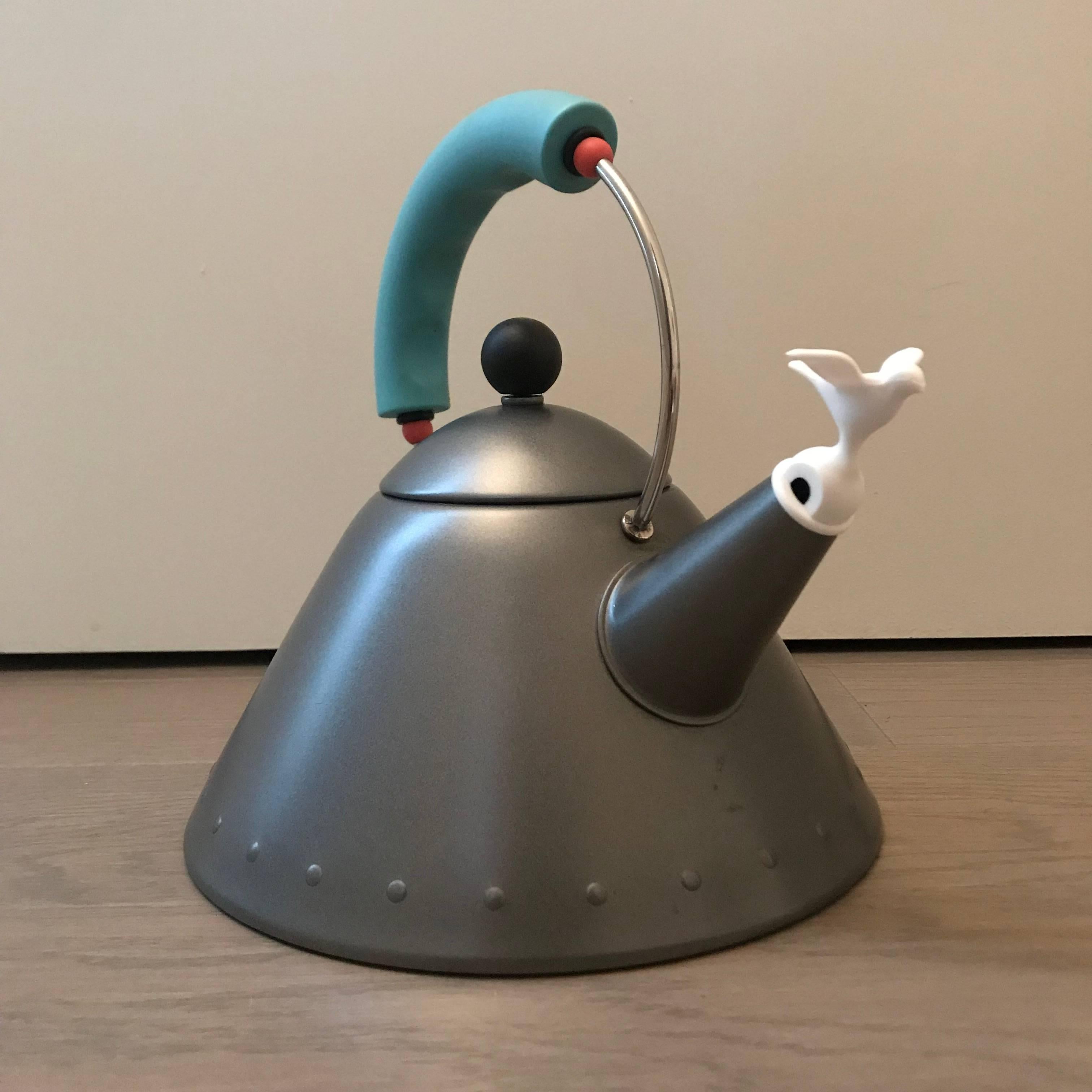 Michael Graves Postmodern tea kettle for Alessi rendered in rare matte platinum grey enamel body, black knob, white whistle bird and turquoise handle with red appointments.
