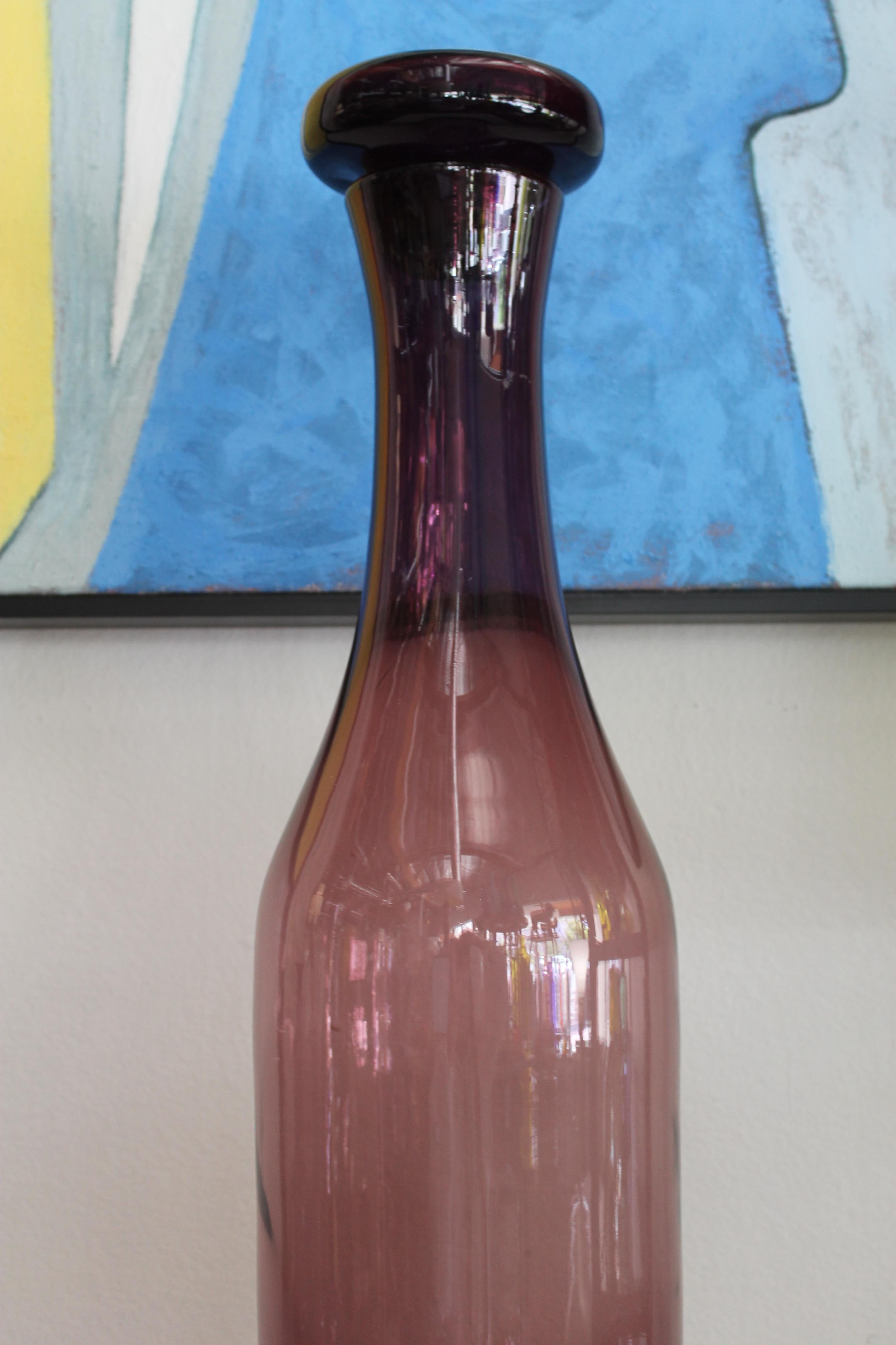 Architectural lilac glass bottle with stopper by Wayne Husted and manufactured by Blenko, USA. Measures 31.5