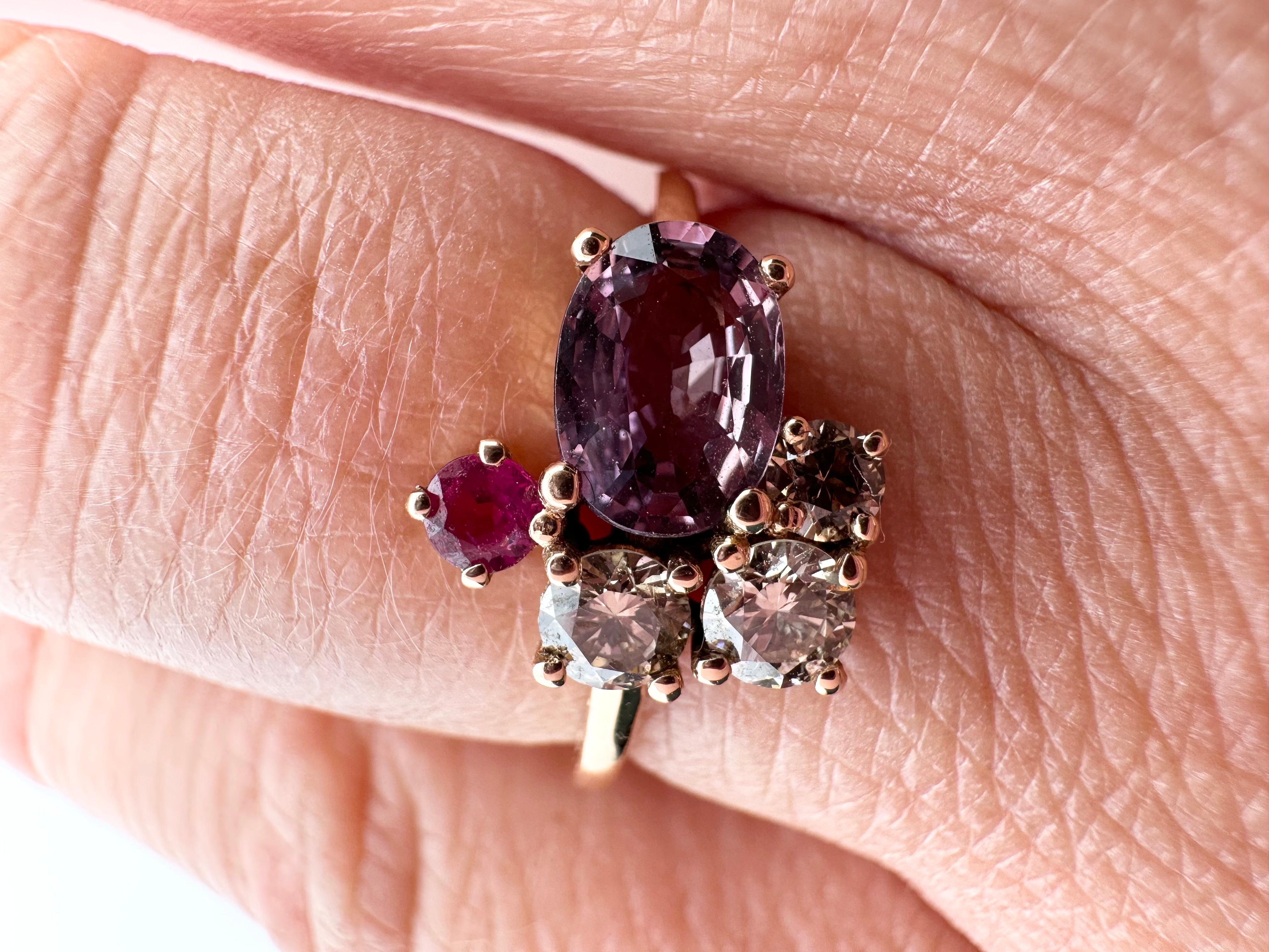 Rare purple sapphire cluster ring with natural champagne diamonds and a ruby, very intersting work of an artist representing so many stones and colors in one ring, very unique and brave presentation. Artist unknown.

Metal Type: 18KT
Gram