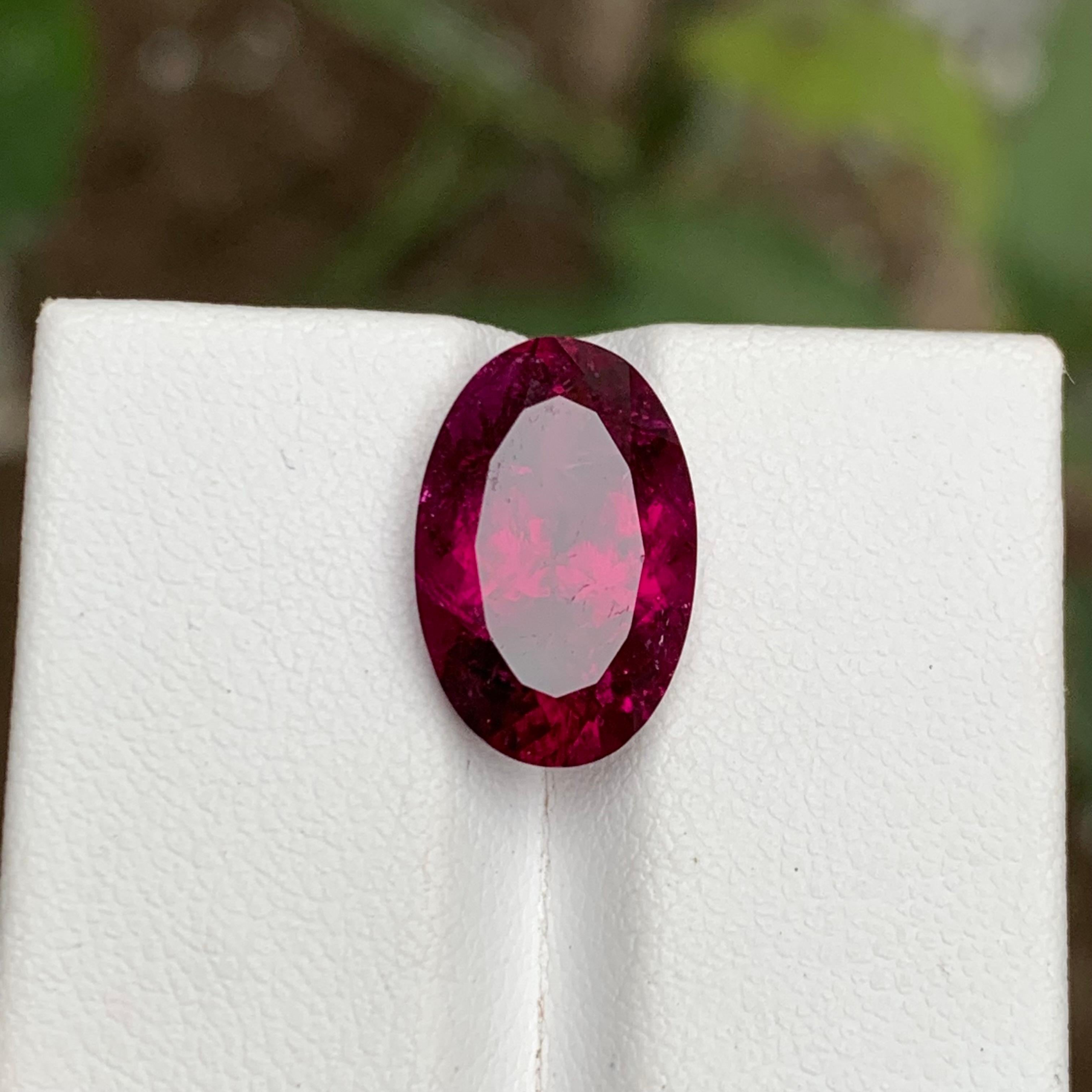 GEMSTONE TYPE: Rubellite Tourmaline
PIECE(S): 1
WEIGHT: 5.80 Carats
SHAPE: Oval Cushion 
SIZE (MM): 14.69 x 9.59 x 6.49
COLOR: Purplish Pink with Red Hues
CLARITY: Moderately Included 
TREATMENT: Heated
ORIGIN: Afghanistan
CERTIFICATE: On