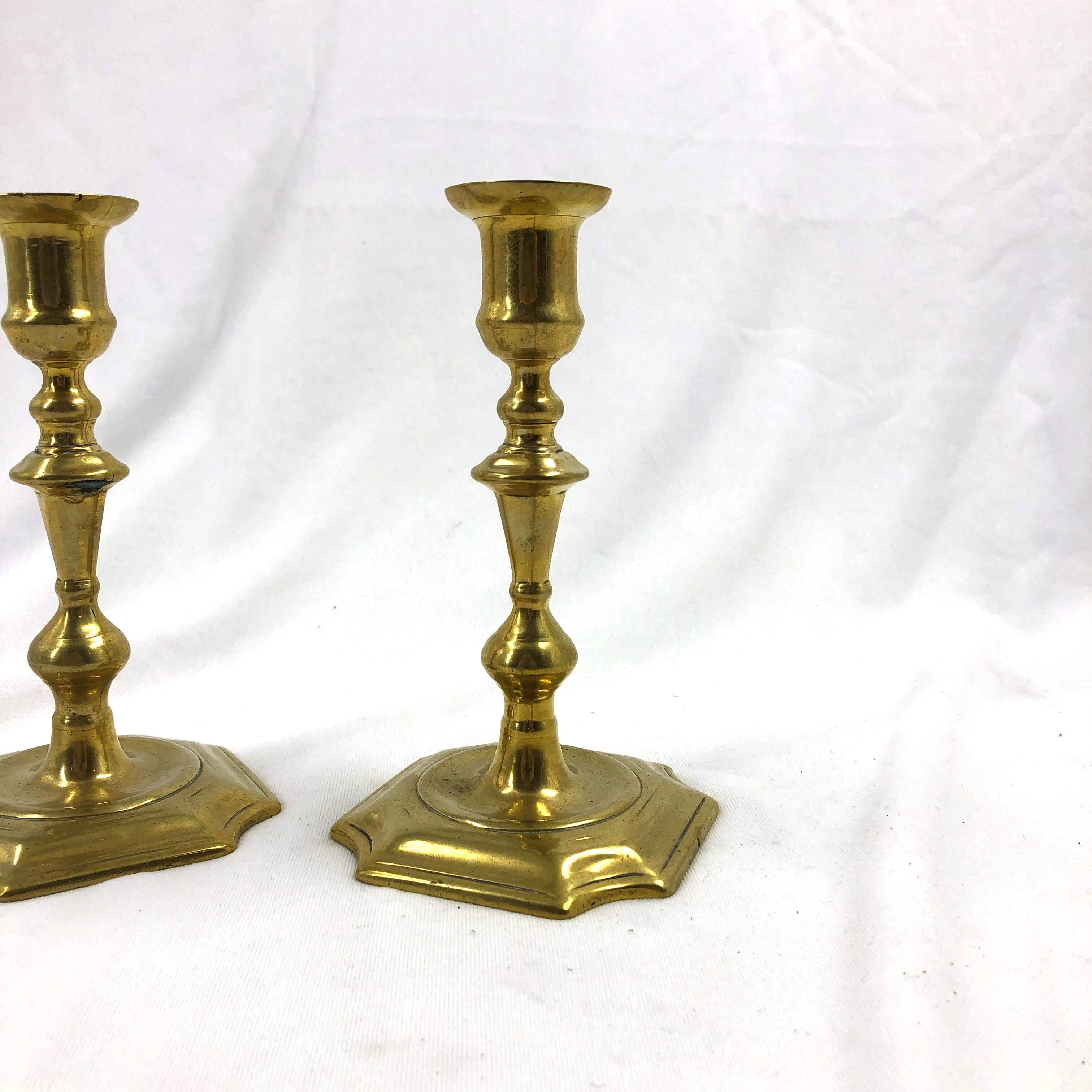 A rare pair of English Queen Anne turned brass candlesticks with incut corners to the bases.