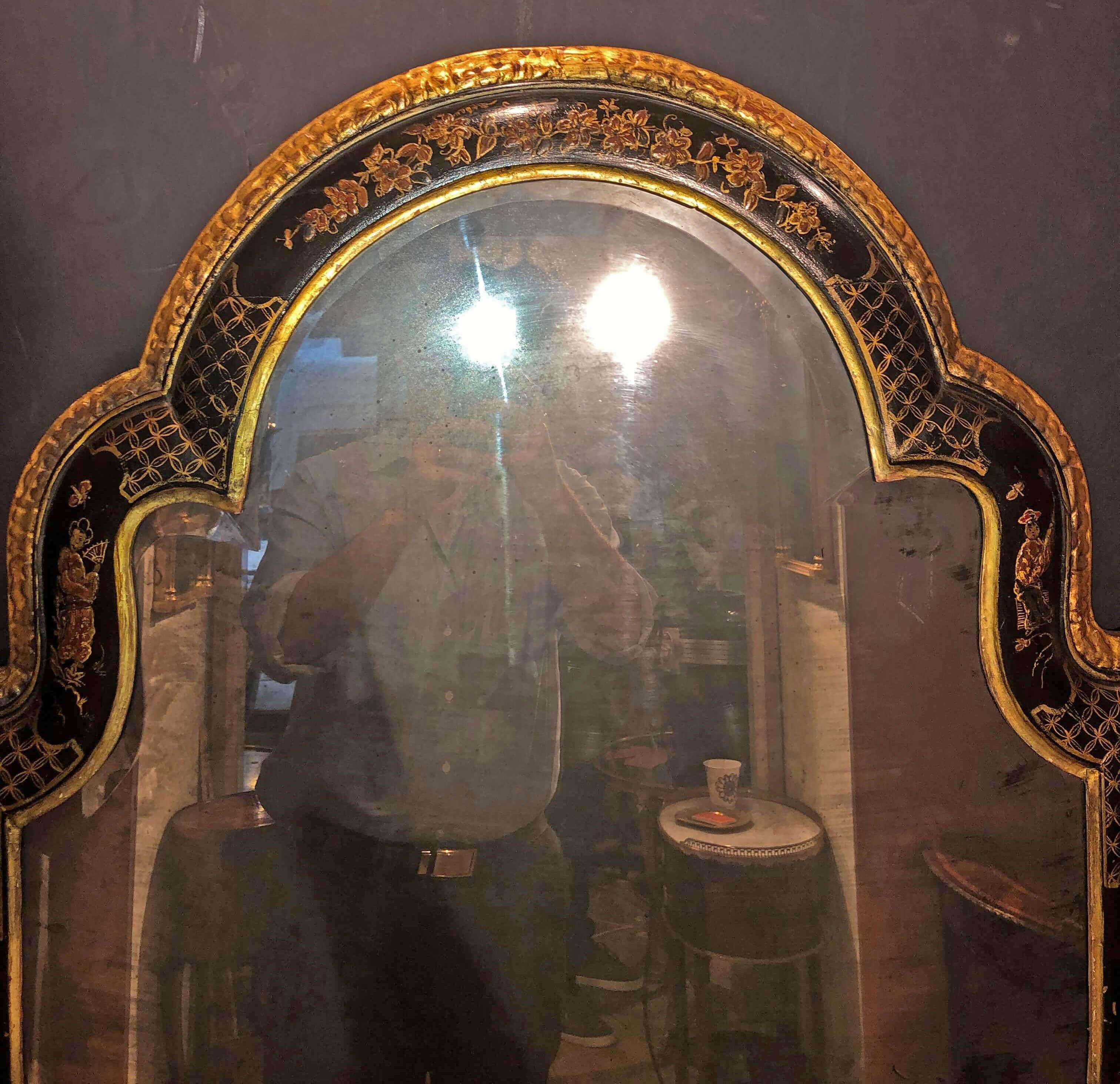 A rare English Queen Anne tombstone form black lacquered chinoiserie decorated Pier mirror with two-part beveled glass and carved gilt edges.
The decoration refreshed.