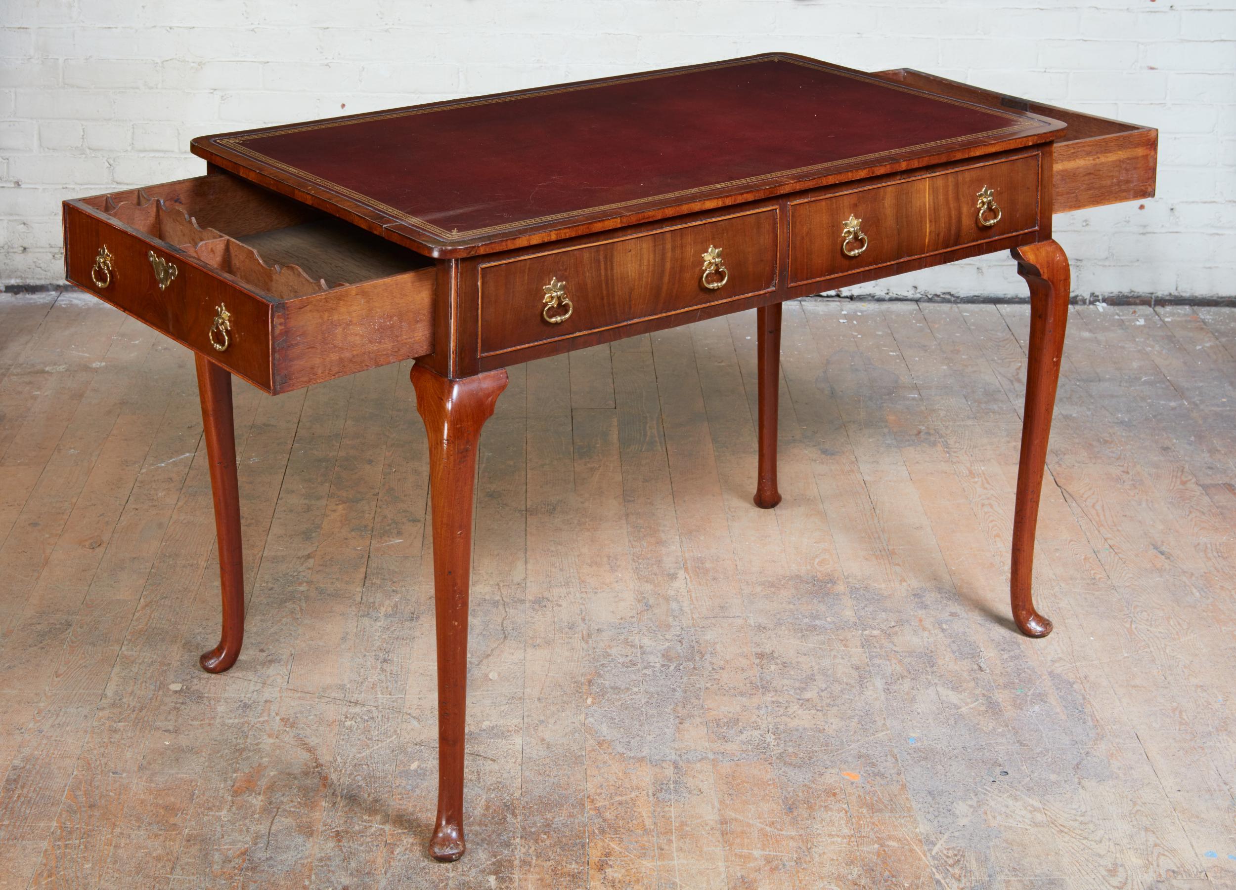 Fine and rare Queen Anne walnut writing table, the leather lined top with walnut crossbanding, all four sides finished with drawers (two real - on the ends and four false - on the sides) one-drawer with scalloped dividers, standing on cabriole legs