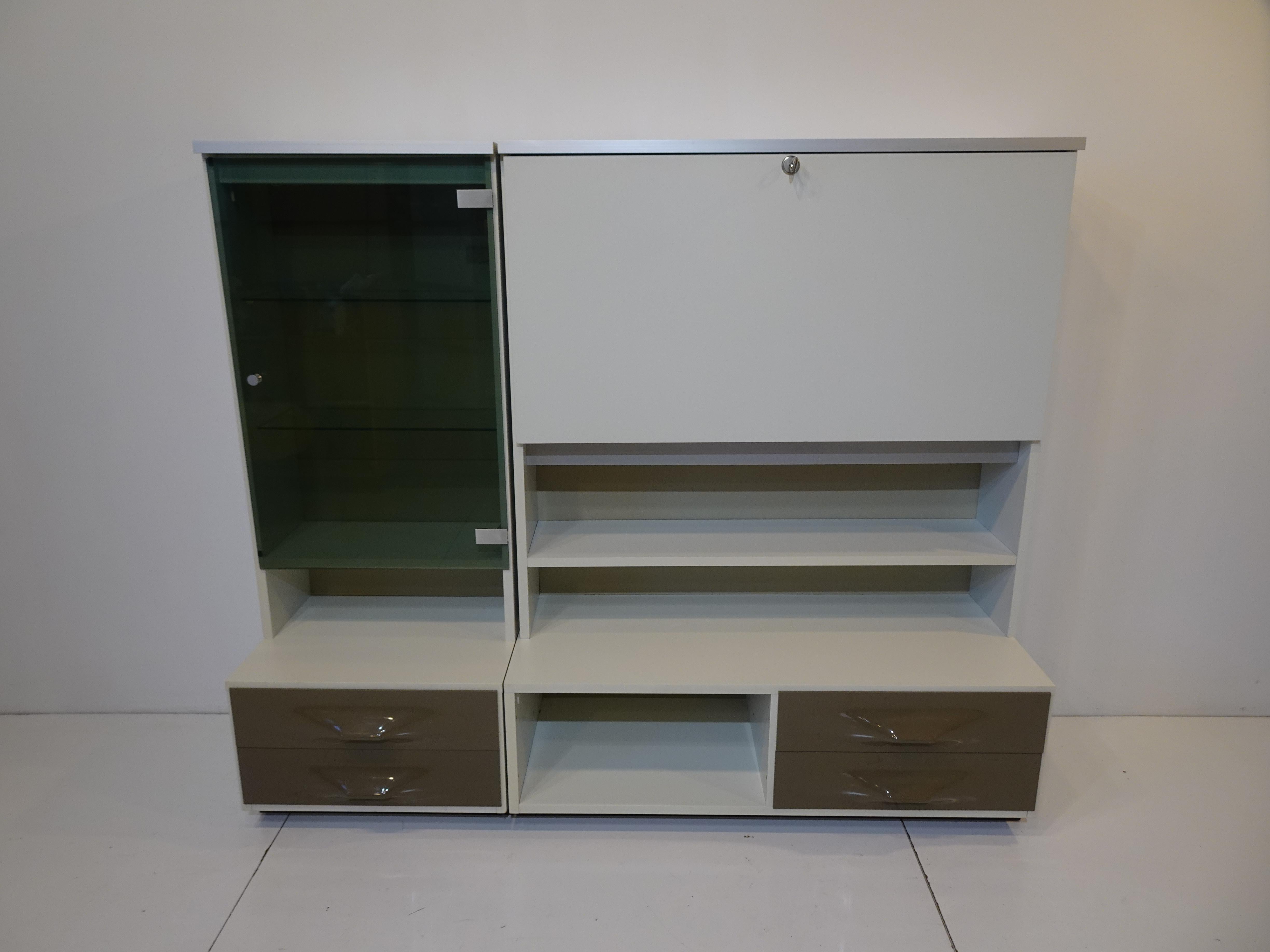 A rare DF 2000 vanity with pull down locking vanity surface, inside having two small glass shelves and a mirror with storage cubies and a jewelry drawer with brushed aluminum pull. To the left side there's a smoked glass door, pull and brushed