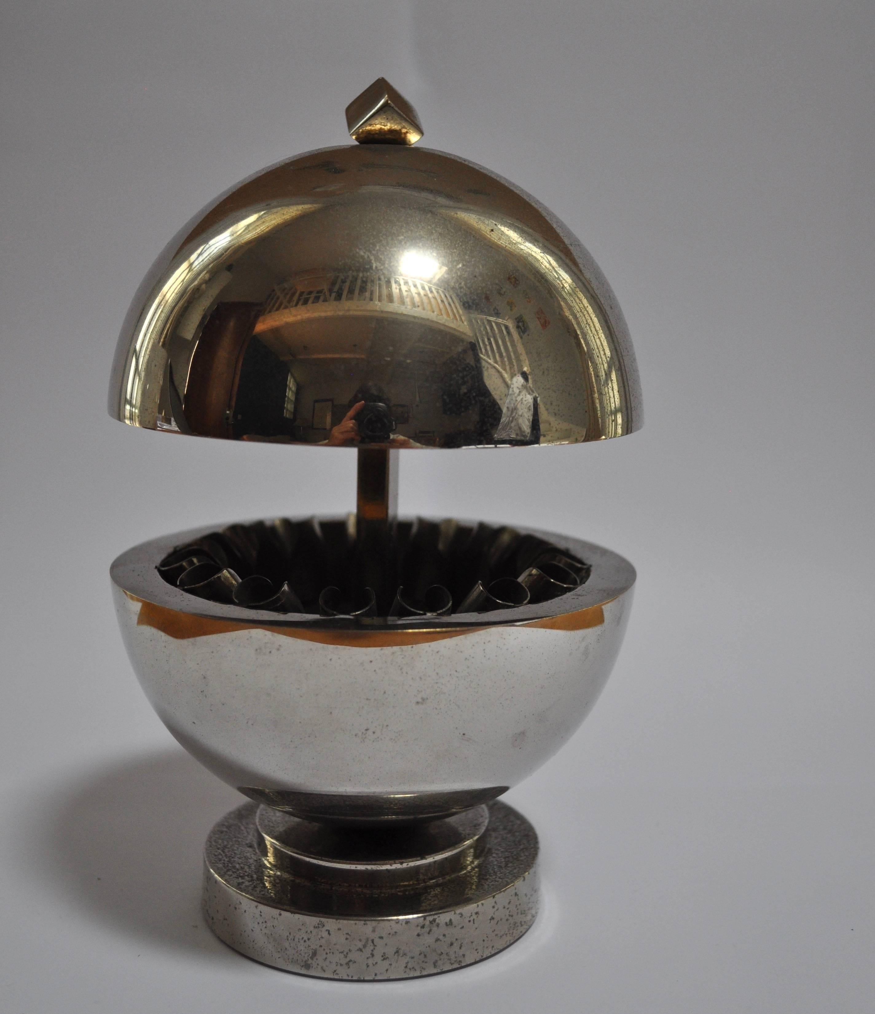 Nickel plated ball shaped cigarettes holder. 

Stamped at the bottom: Raymond Mauny, France, Paris
He was a creator of parisian maison Desny.
Excellent example of French modernist design.