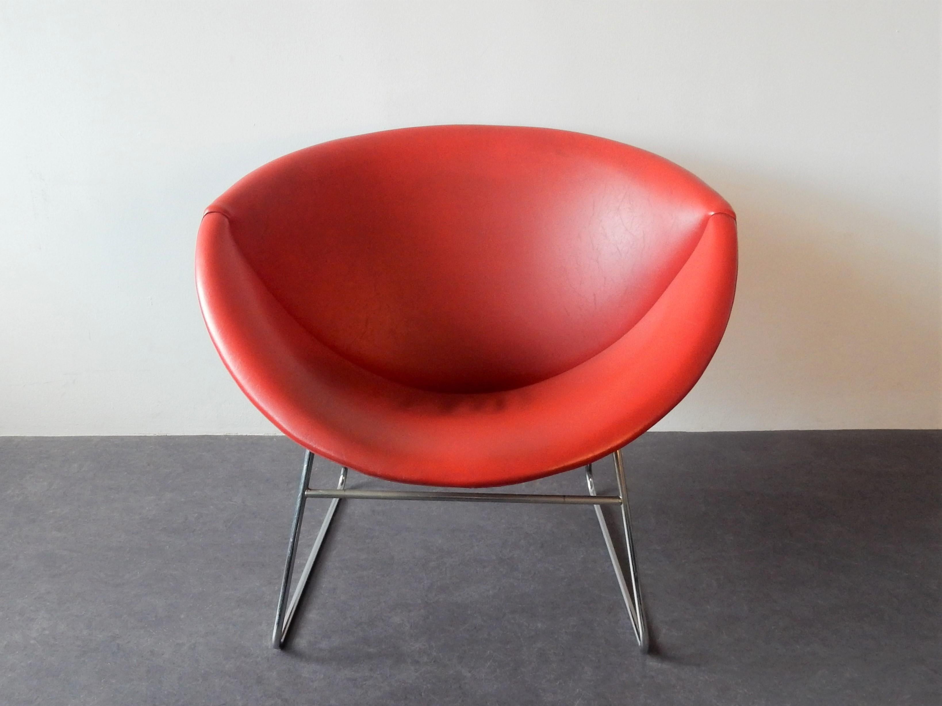 This organic shaped lounge chair, model Cocco, was designed by JH Rohe for the Dutch manufacturer Rohé in Noordwolde. It has a slim chrome frame with a nice shell-shaped seat element that is upholstered with (original) red faux leather. All in a