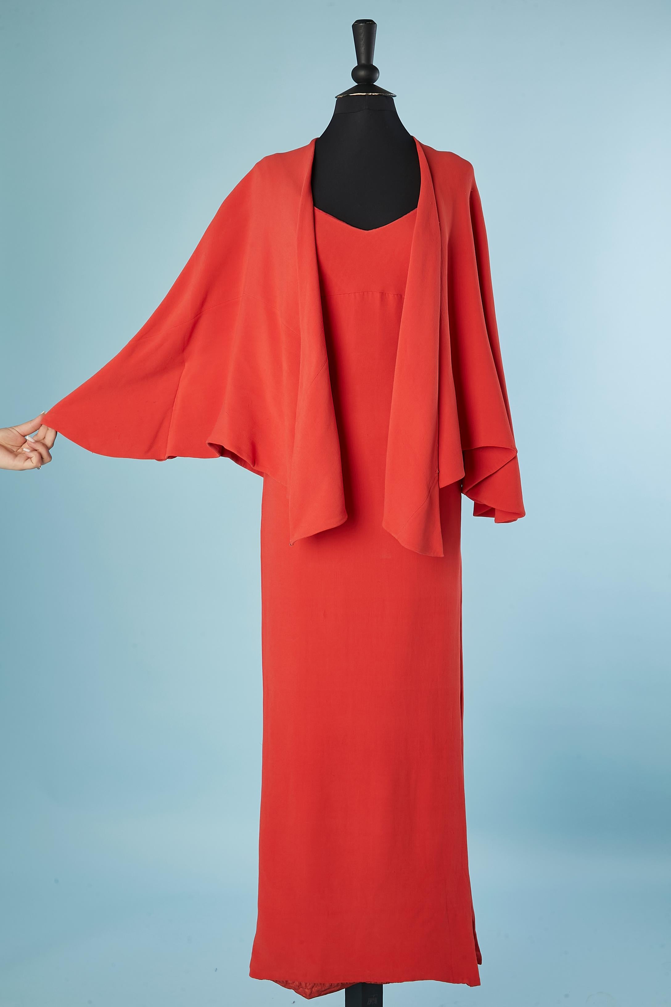 RARE robe du soir en crêpe rouge doublement doublée avec cape. 
Fermeture éclair et crochet sur le côté gauche de la robe + fente sur le même côté, longueur= 32 cm.
Petit poids à l'intérieur de la robe dans le dos pour conserver l'équilibre du