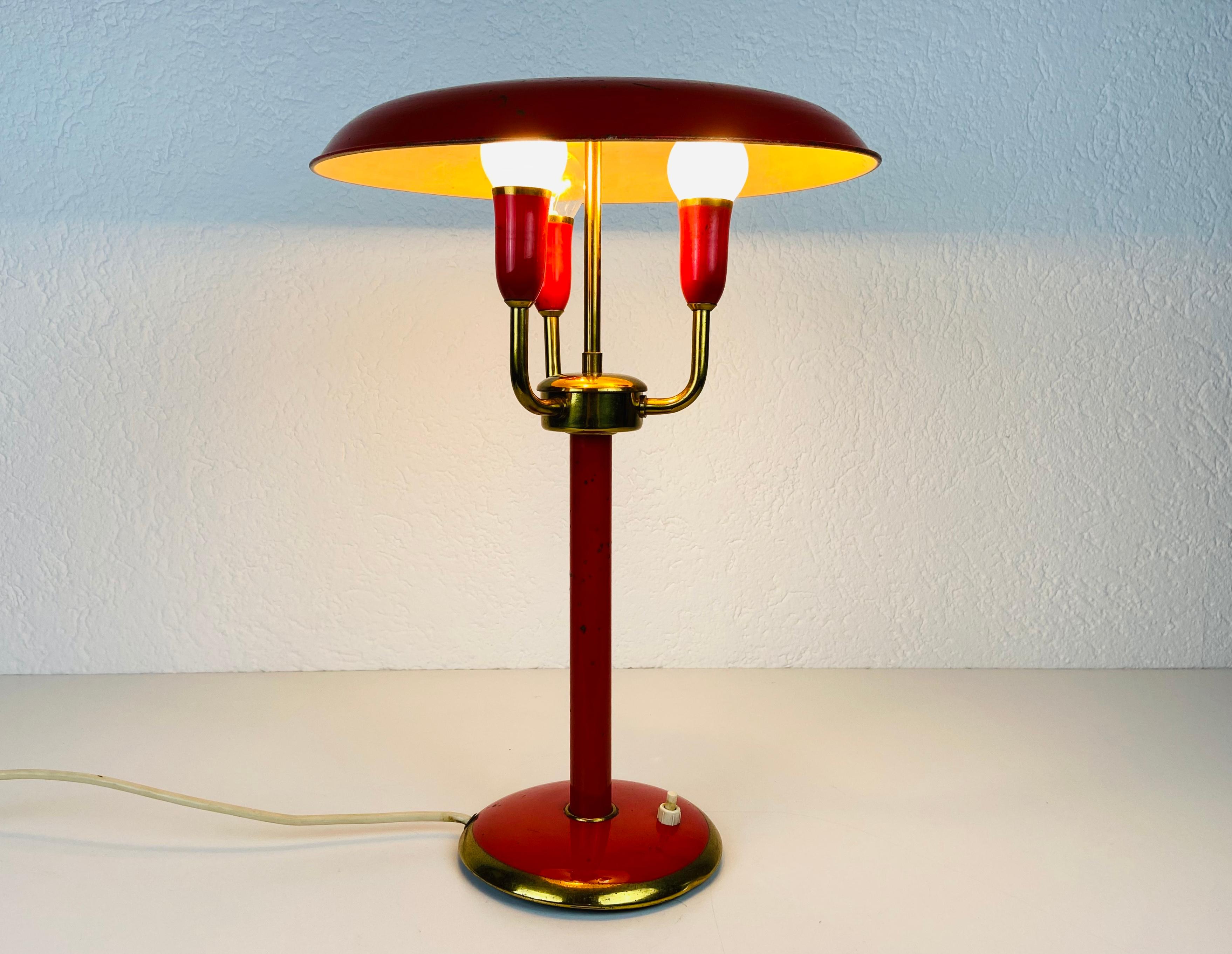 Une lampe de table italienne fabriquée dans les années 1960. Fabriqué en métal et en laiton. L'éclairage a un design exceptionnel avec 3 bras.

Le luminaire nécessite trois ampoules E14. Fonctionne avec les deux 120/220V. Bon état