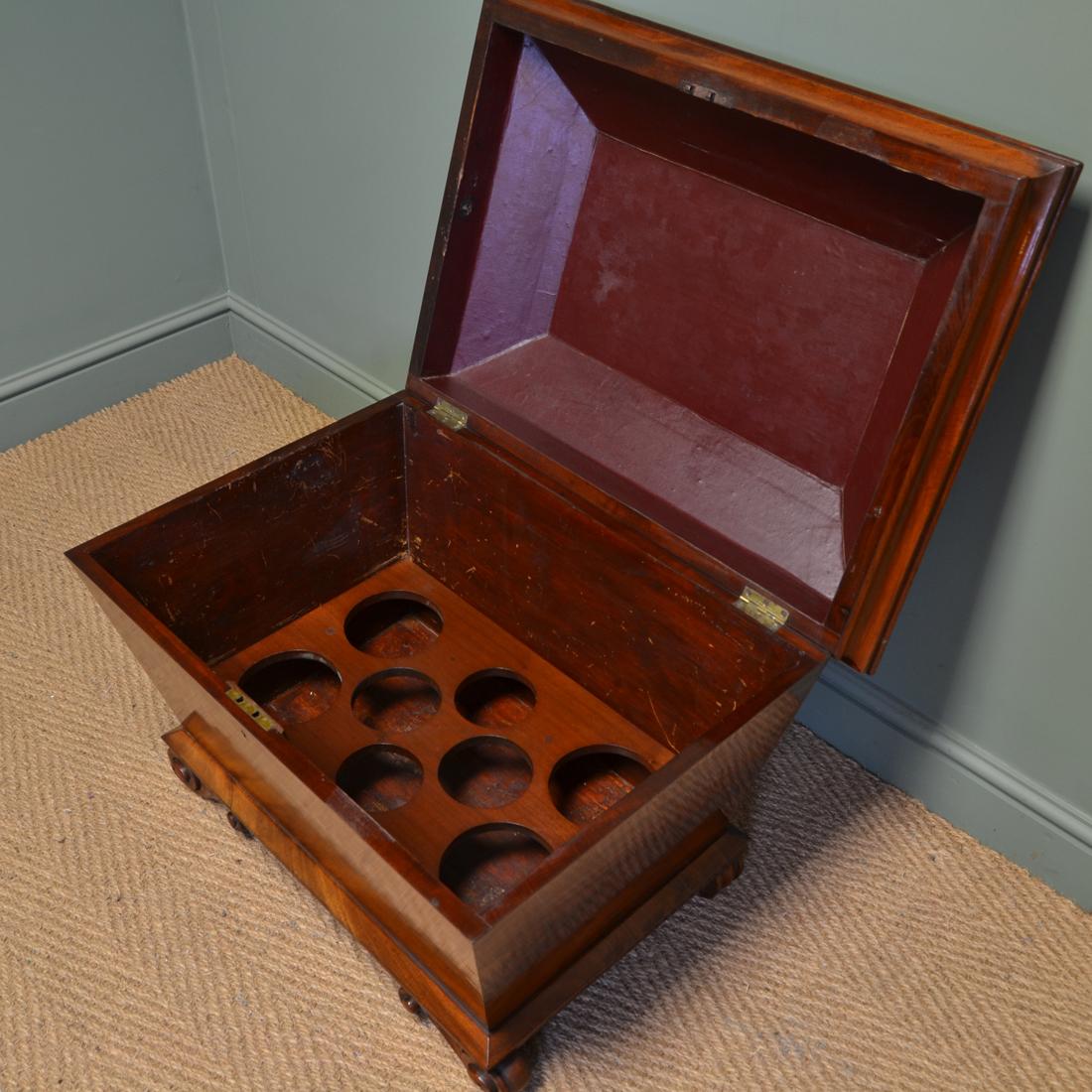 Rare Regency figured mahogany large antique cellaret / wine box

This rare regency antique cellaret / wine box, circa 1830 has a moulded top on a tapering body with unusual scrolled carved feet. The lid lifts up to reveal an interior that is