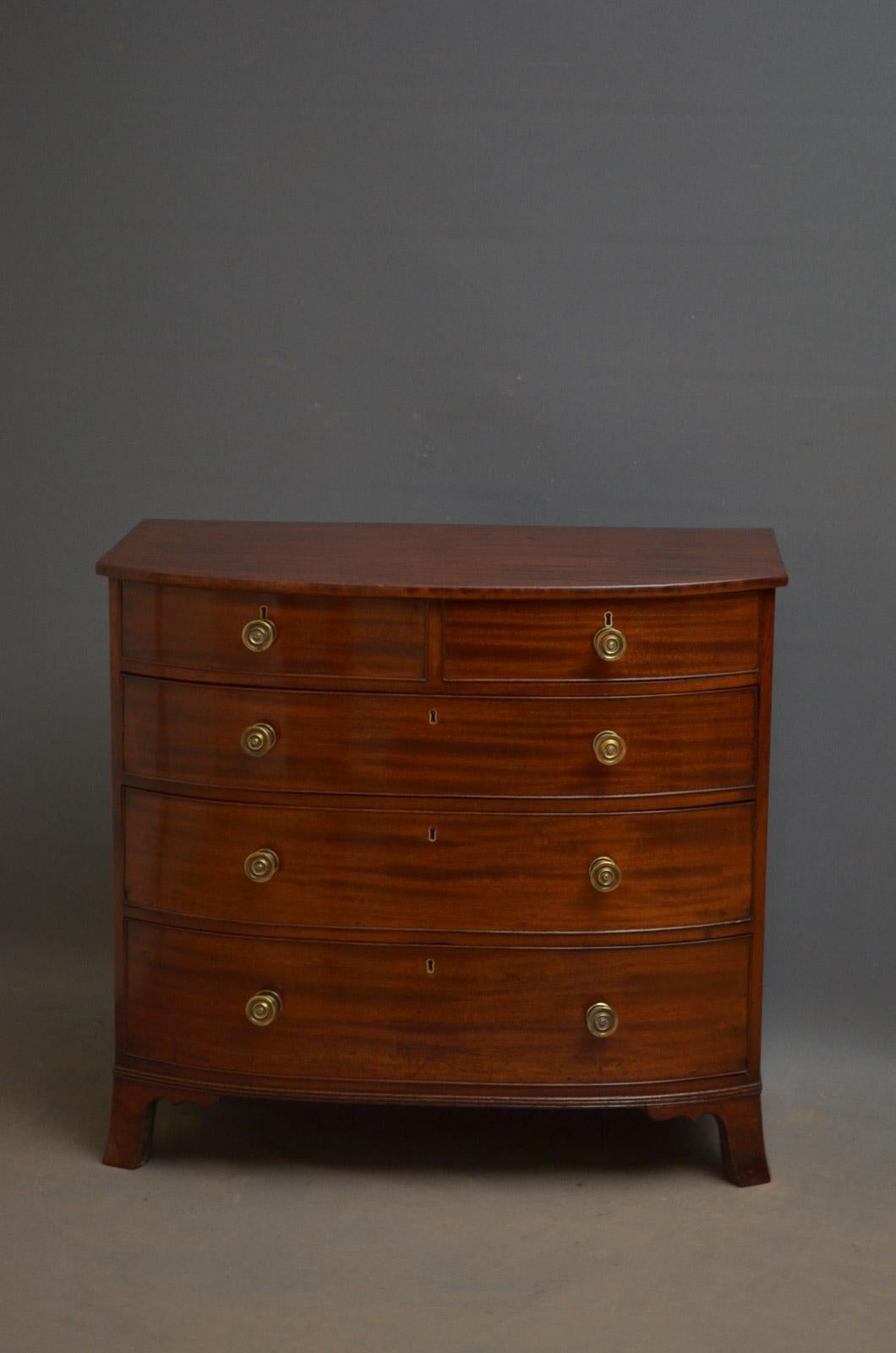 Sn4394, elegant Regency bow fronted chest of drawers of diminutive proportions, having figured mahogany top above two short and three long graduated and cockbeaded drawers (one with compartments ), all fitted with original brass handles , standing