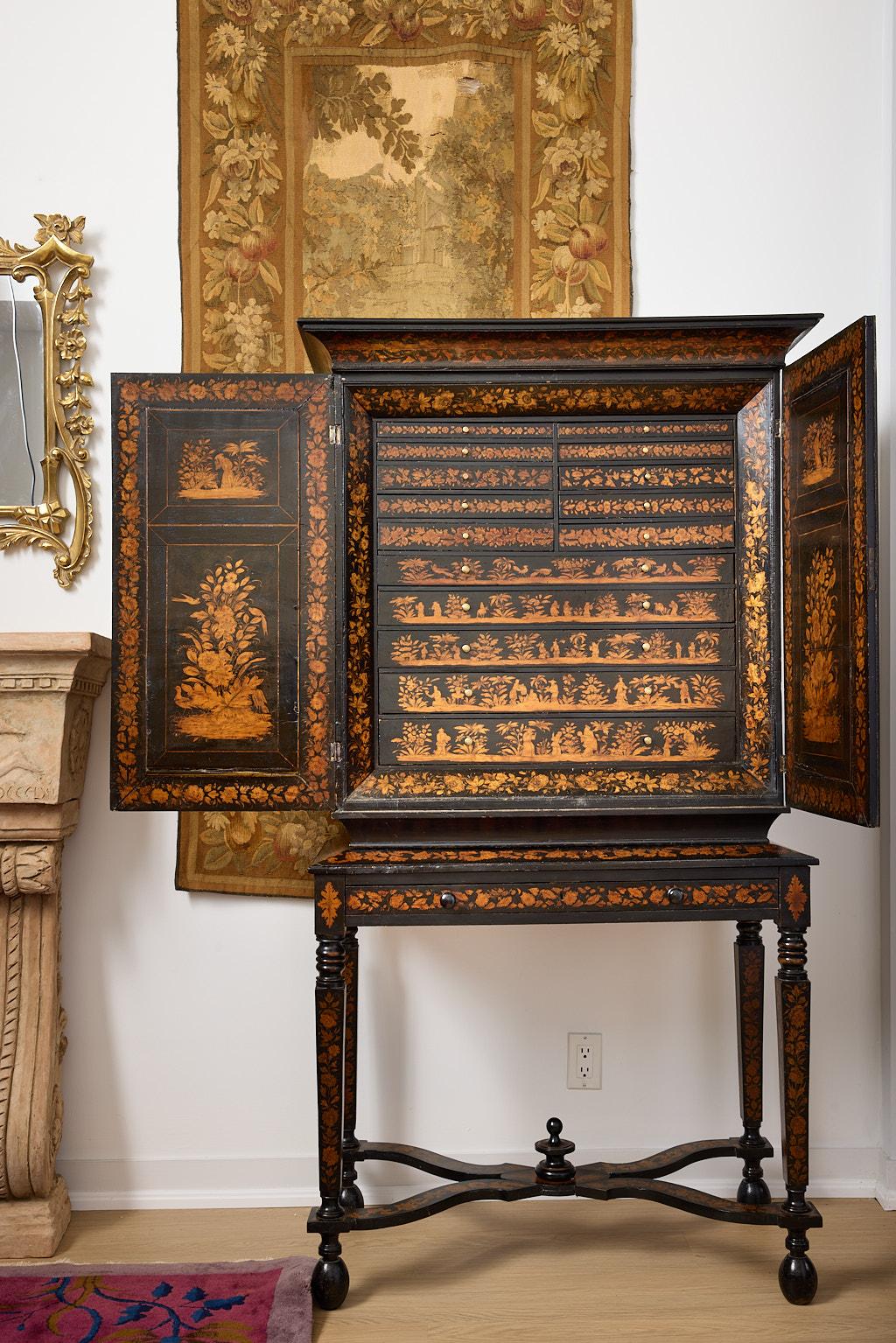 Il s'agit d'un rare cabinet de collectionneur anglais d'époque, vers 1800, en laque, avec une décoration figurative au Penwork. Les doubles portes s'ouvrent pour révéler quinze tiroirs encastrés dont l'intérieur est recouvert d'une doublure rose
