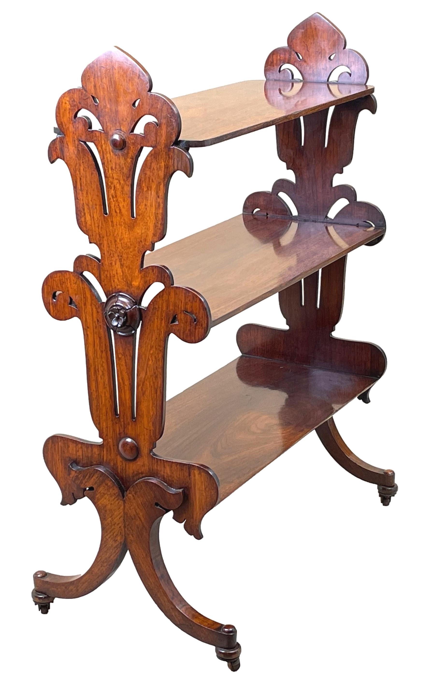 A very unusual and extremely good quality 19th century late Regency period rosewood étagère, or freestanding open bookshelf, having three superbly figured tiers flanked by elegant shaped and pierced end supports with attractive carved patrae,