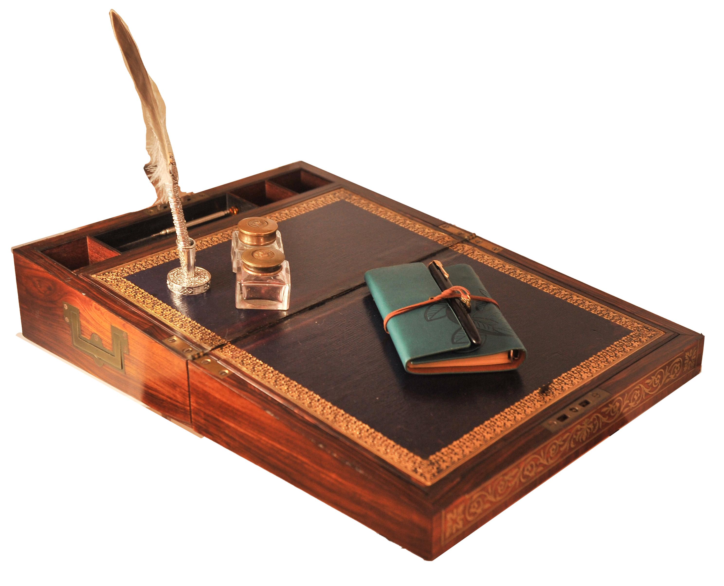 Handcrafted 19th Century Rosewood Veneer Writing Slope With A Tooled Purple Leather Writing Liner. Item Featured Brass Carry Handles & Is Finished With A Decorative Brass Inlay. Manufactured By Esteemed Maker Wells & Lambe.

Item will include new