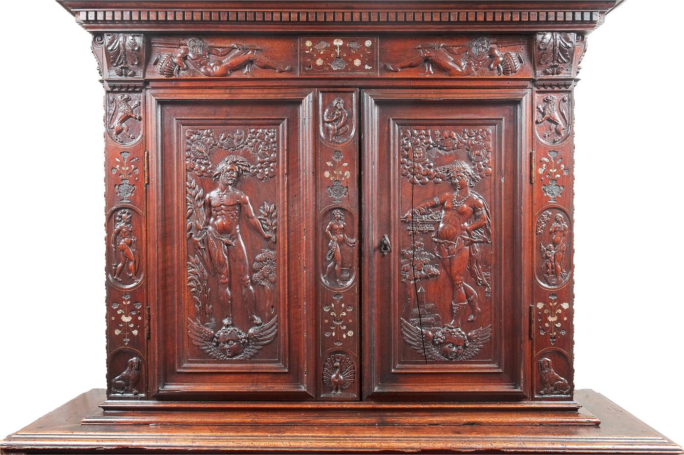 This rare Renaissance cabinet is richly decorated on the doors and drawers with carvings depicting the four seasons, and on the uprights and the entablature, alternating flower bouquets inlaid with mother of pearl. This is a beautifully conceived