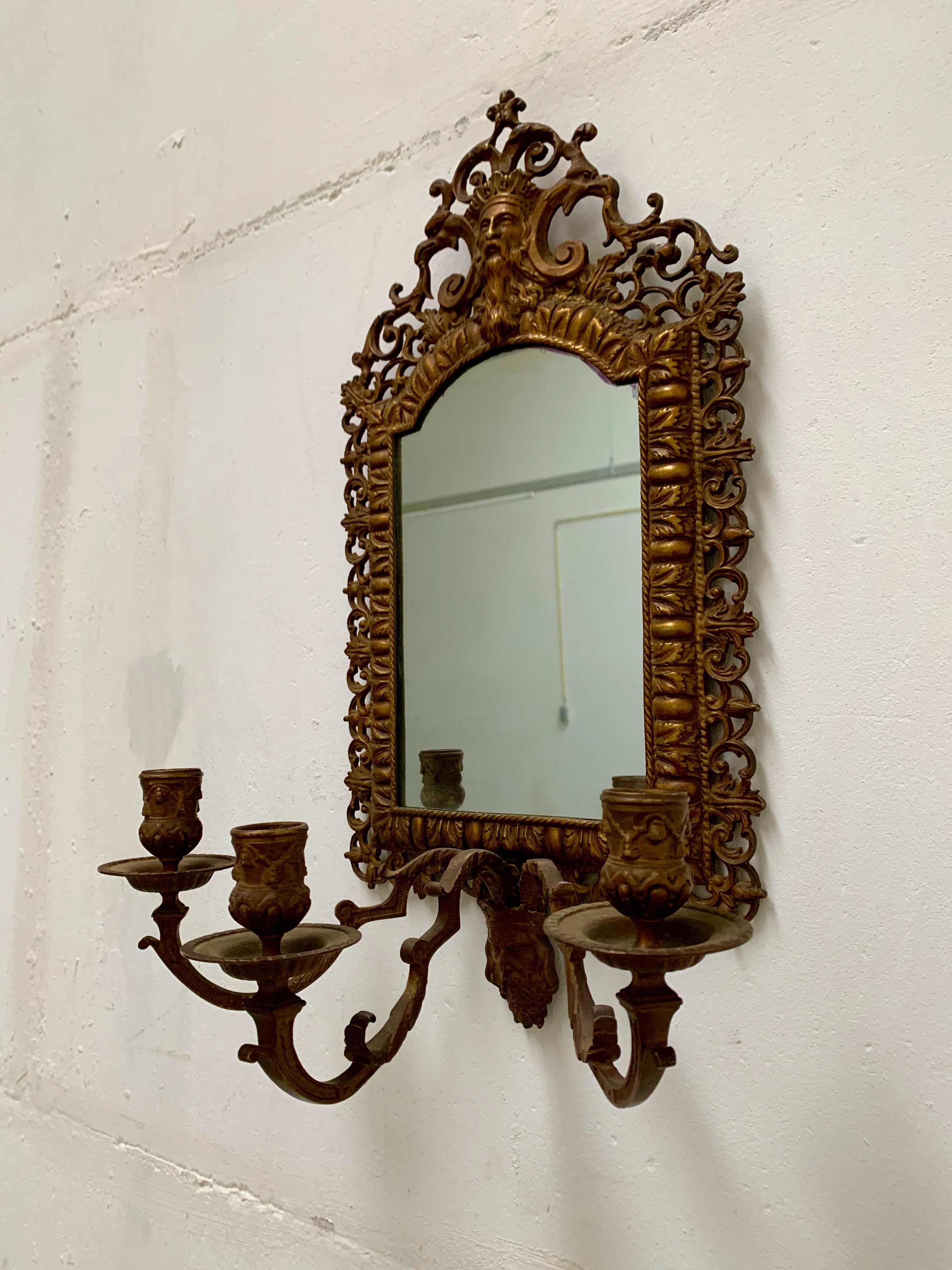 Antique mirror wall sconce with integrated candelabras.

This antique sconce is ideal for wall decoration and the look and feel is just wonderful. The impressive, cast bronze heads or masks on top and at the bottom are of a quality and beaty that
