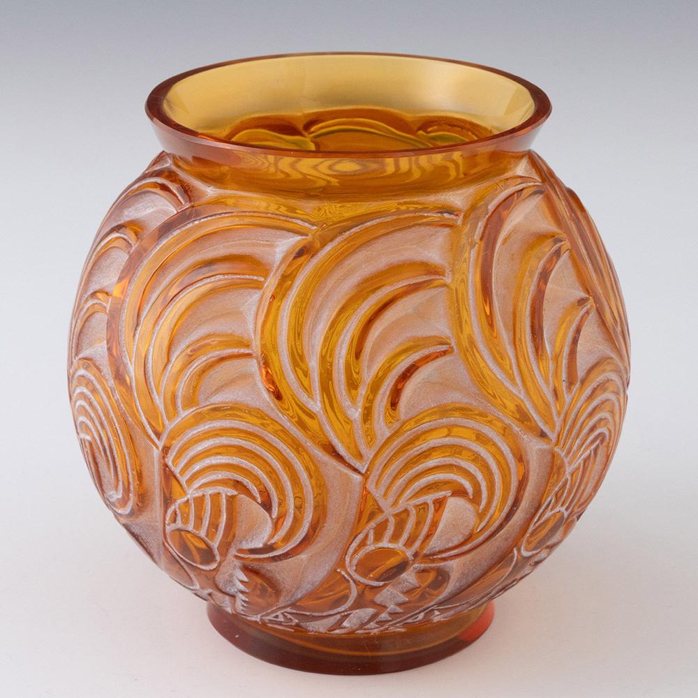 Titolo : Raro vaso di Bresse di Lalique
Data : 1931
Origine: Francia
Caratteristiche della ciotola: Ambra con macchie bianche. Il disegno rappresenta dei galli che beccano il terreno con le esuberanti piume della coda.
Marchi: incisione all'acido R.