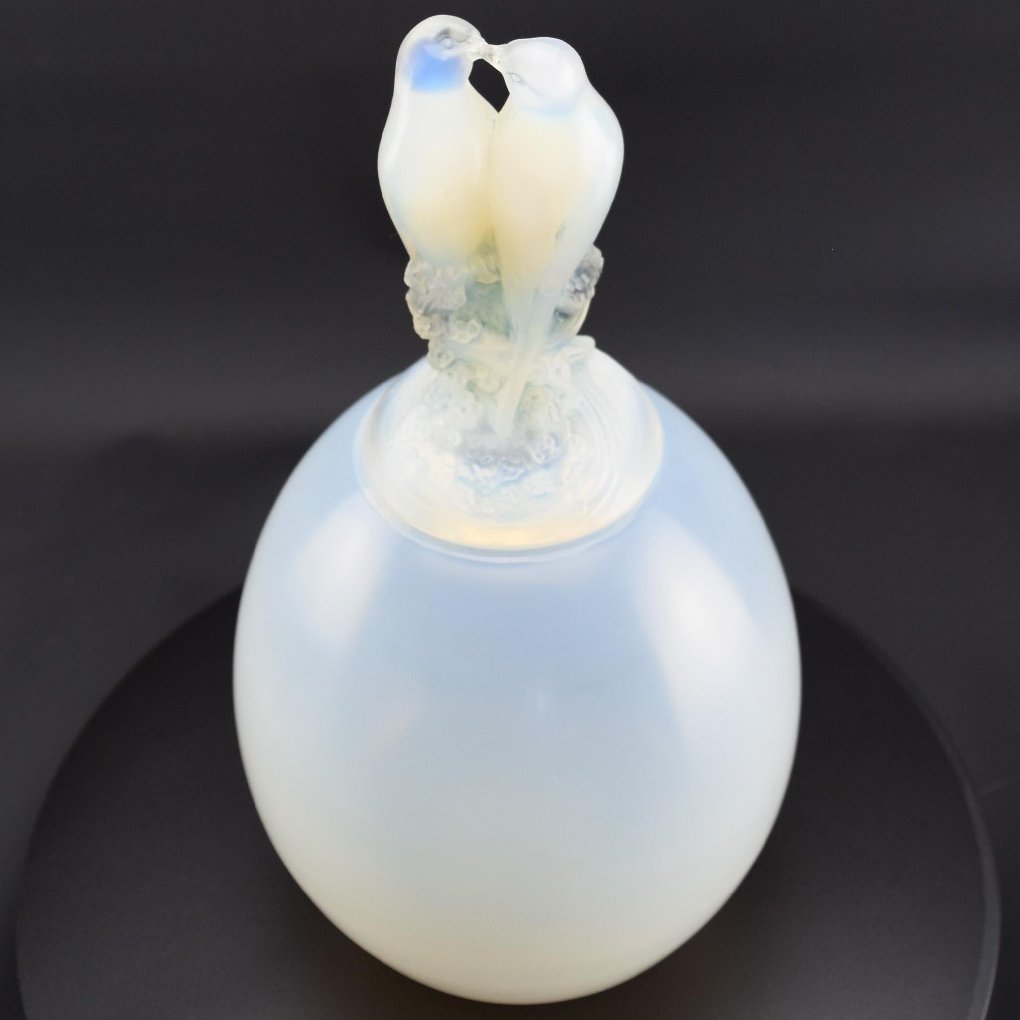 Vase à couvercle Tourterelles opalescent de René Lalique en verre opalescent profond rehaussé de taches bleues.

Vase rare et difficile à trouver, de forme ovoïde, dont le couvercle représente deux tourterelles enlacées.

Gravé sur la base R Lalique