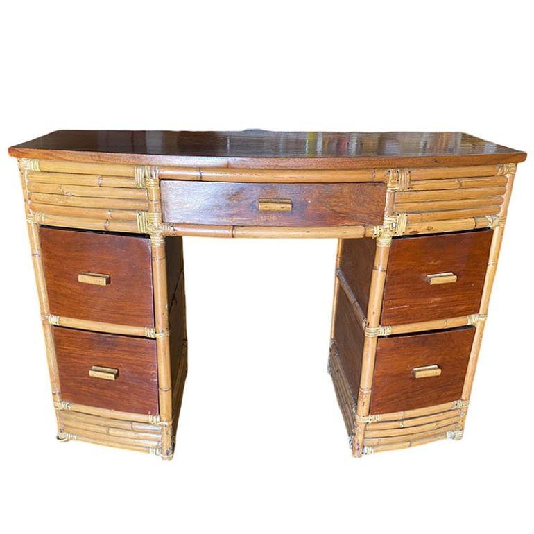 Questa splendida scrivania in rattan impilato di metà secolo, ispirata a Paul Frankl, è stata restaurata con frontali dei cassetti, pannelli laterali e piano in mogano filippino e una struttura in rattan. La scrivania presenta un cassetto centrale e