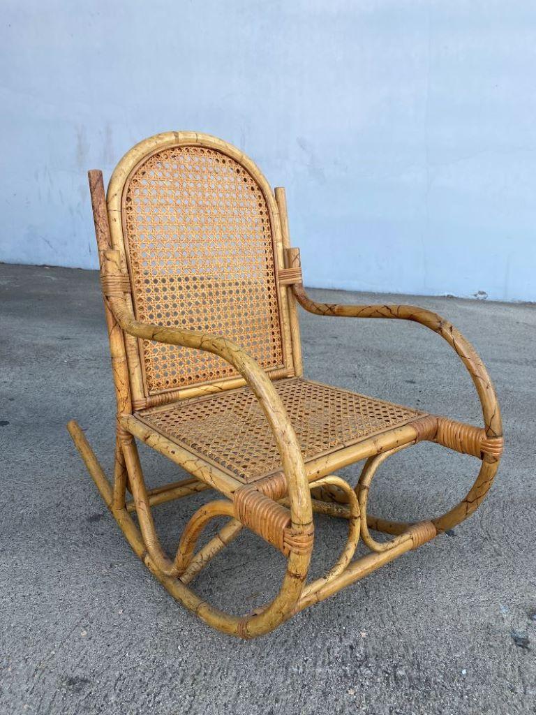 Rare Post-War child-size tiger bamboo rocking chair with bend arched sides and woven wicker seats.

Chair: 26